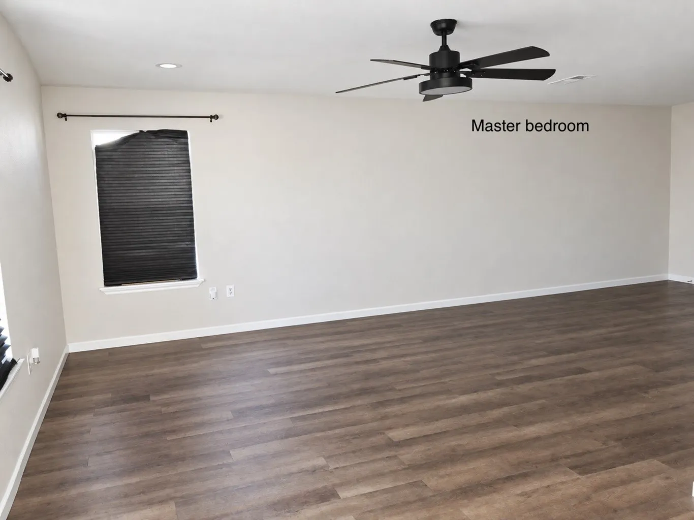 Room featuring wood-finish flooring, recessed lighting, and a matte black ceiling fan with an integrated light fixture