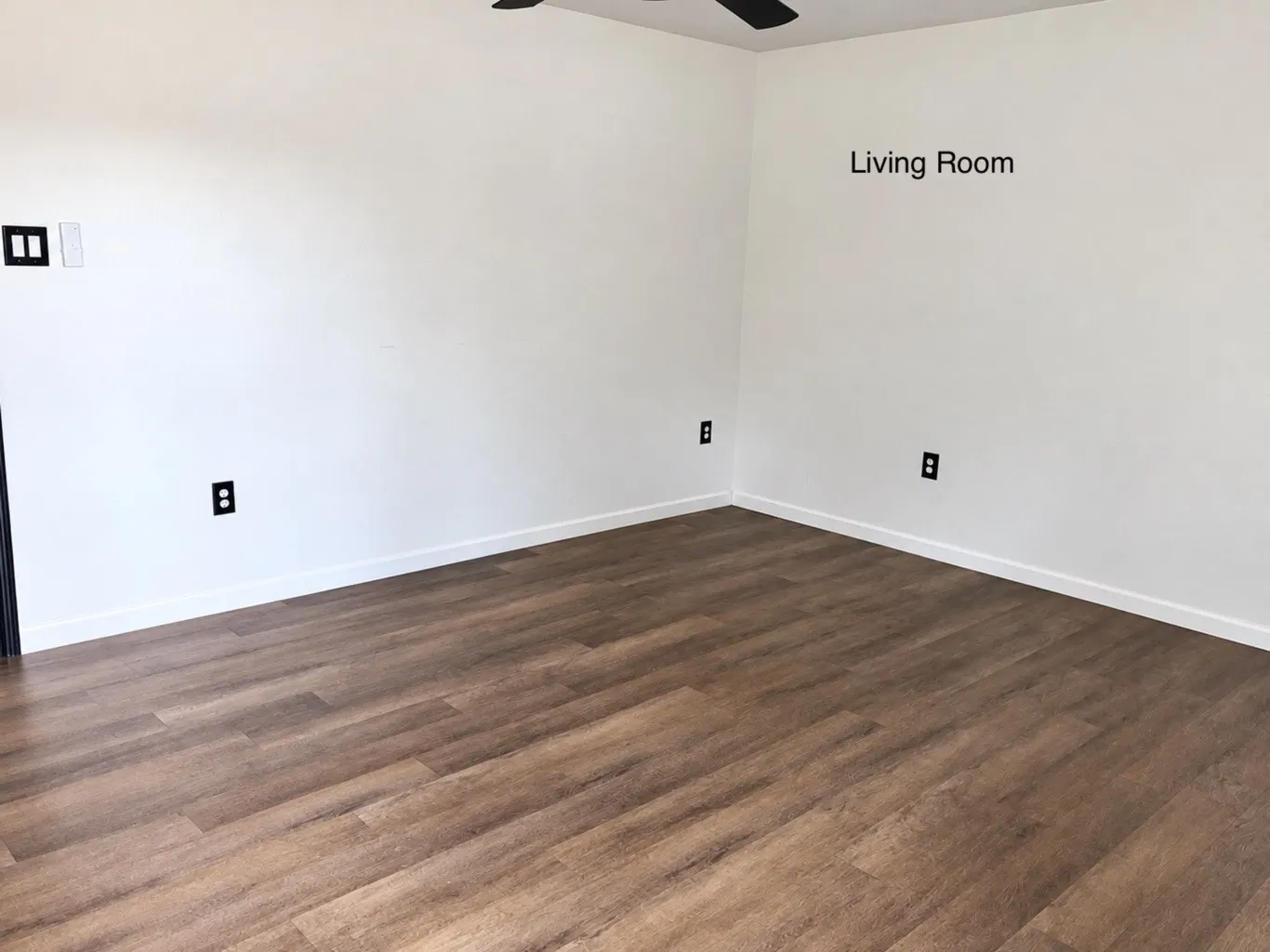 Neutral-toned walls and wood-finish flooring featuring a ceiling-mounted light fixture