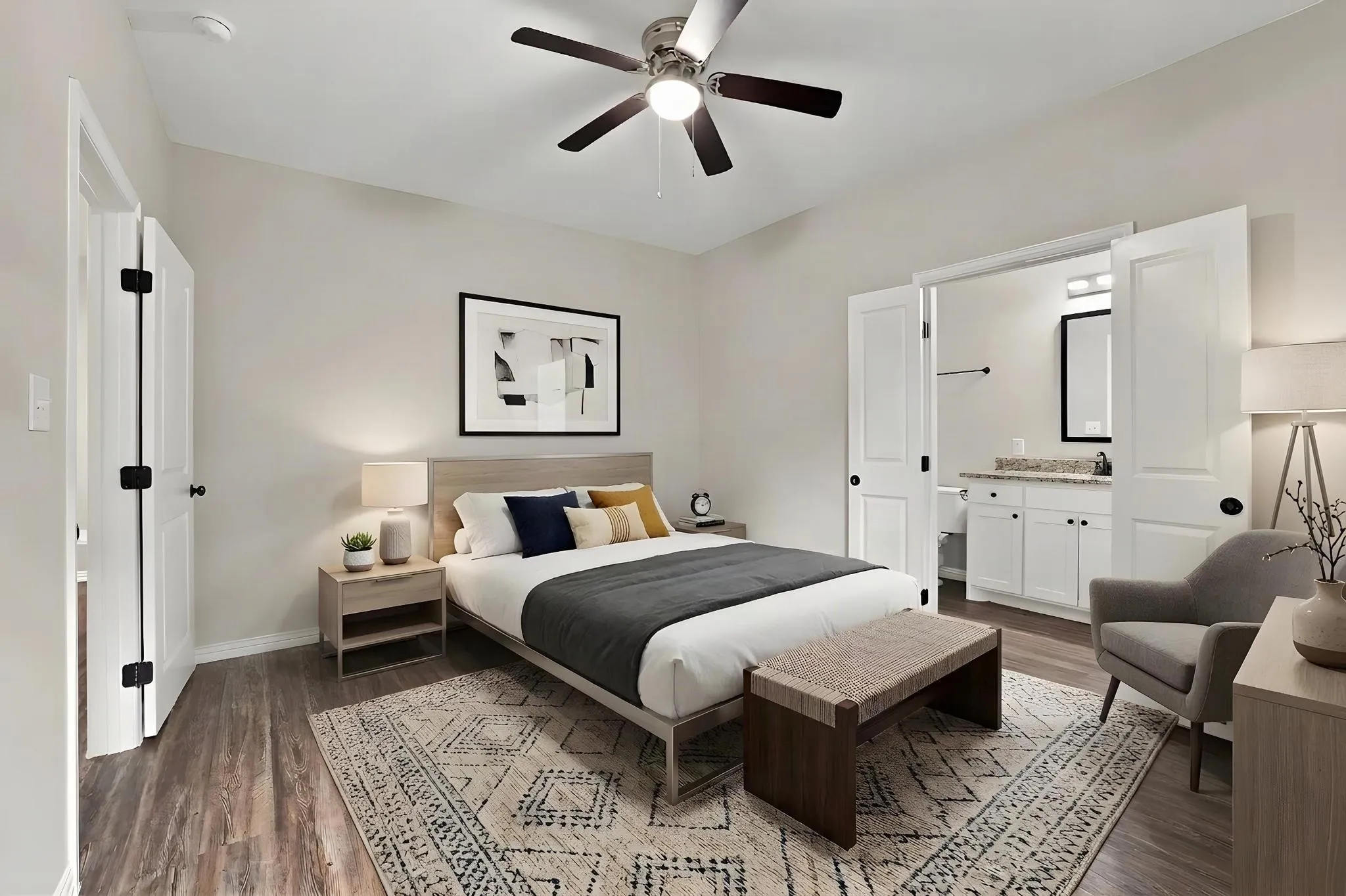 Neutral-toned bedroom featuring wood-finish flooring, a ceiling fan with integrated lighting, and double-door entry to the bathroom