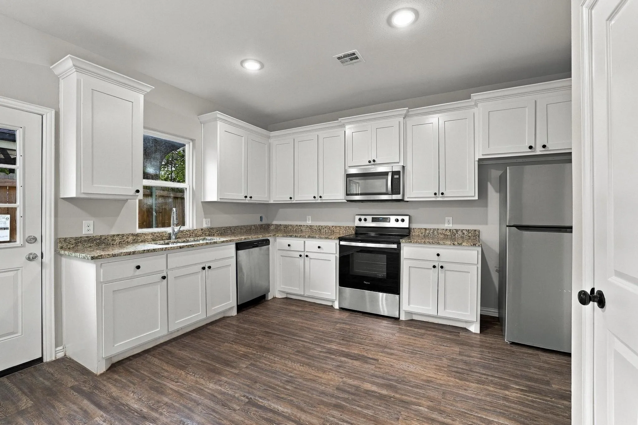 Kitchen featuring white cabinetry, stone-finish countertops, stainless steel appliances, recessed lighting, and wood-finish flooring