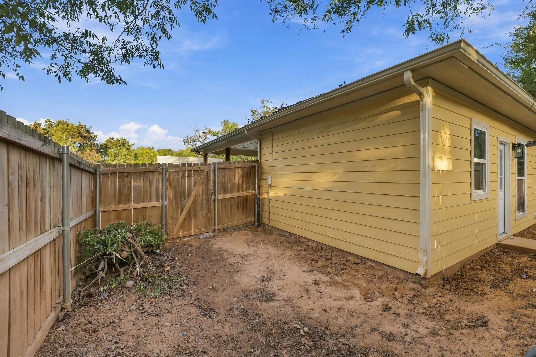 Exterior horizontal siding, wood privacy fencing, and gated access