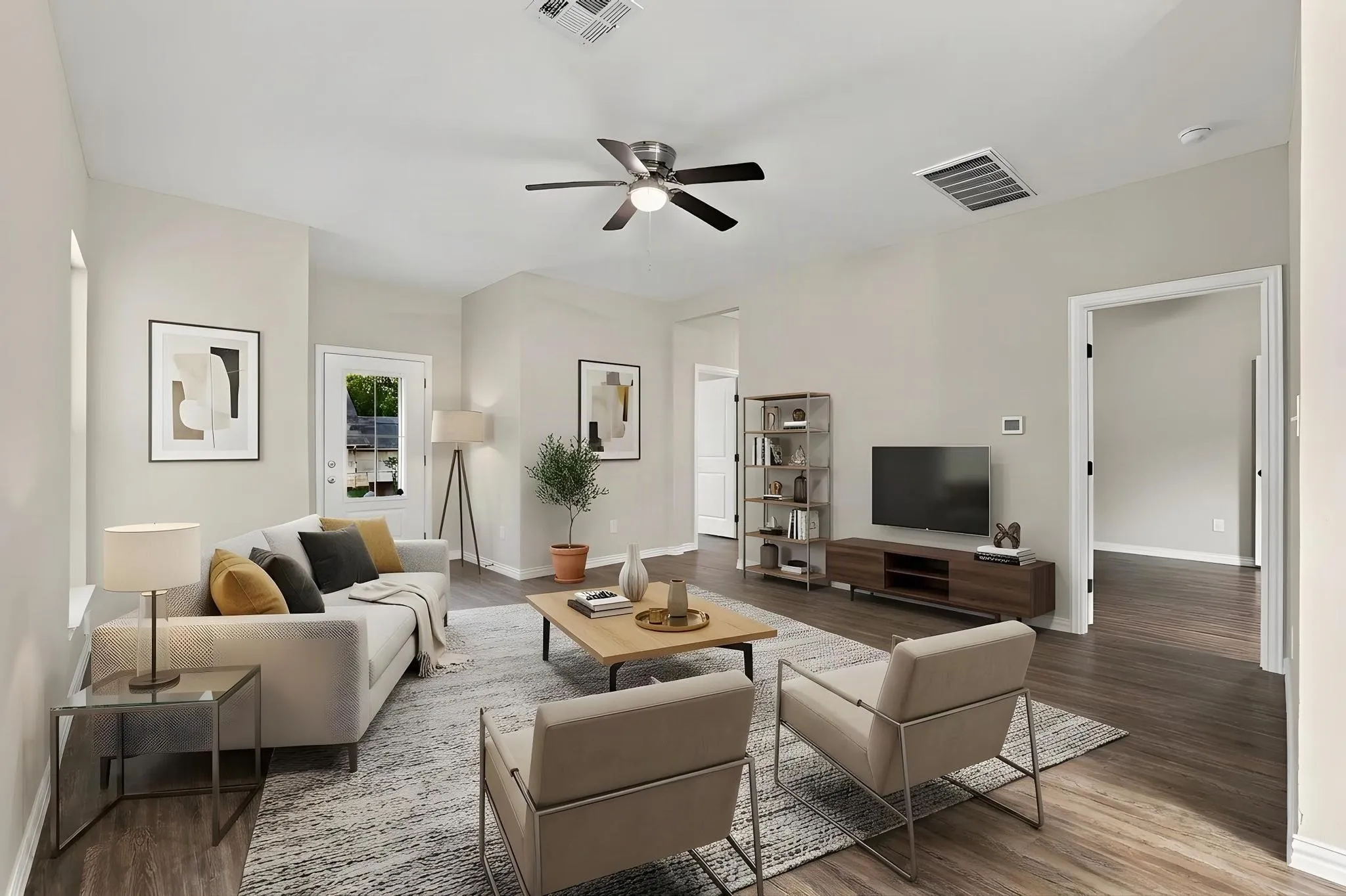 Neutral-toned walls paired with wood-finish flooring, featuring a ceiling fan with integrated light fixture and multi-panel door entry