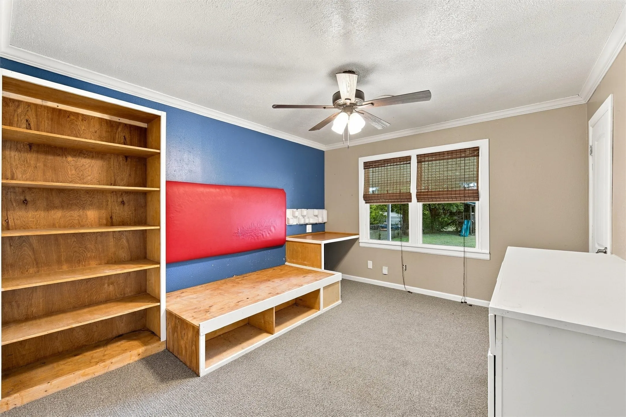 front bedroom with custom built captains bed, shelving, desk and dresser