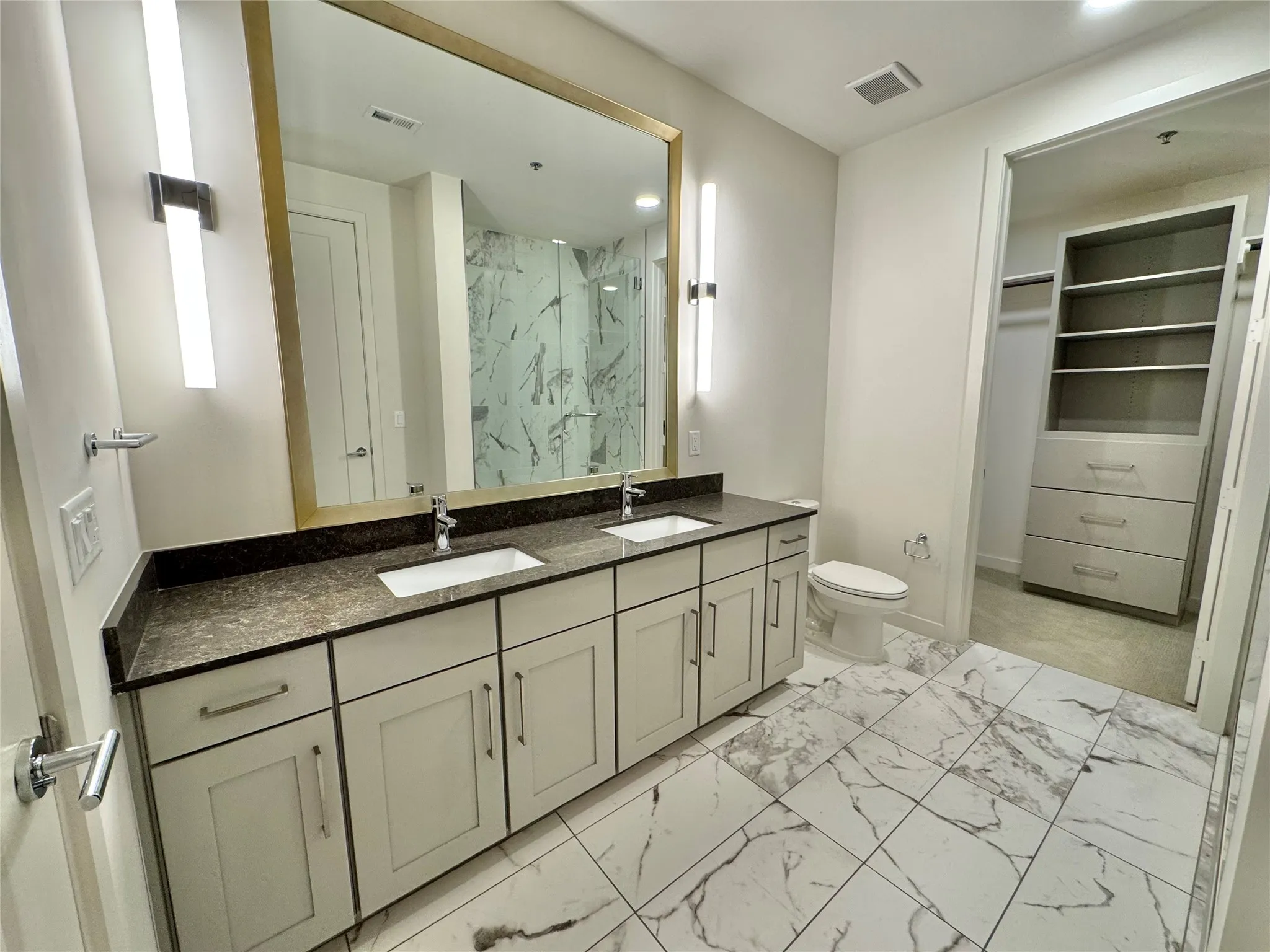 Bathroom with vanity, toilet, and walk in shower