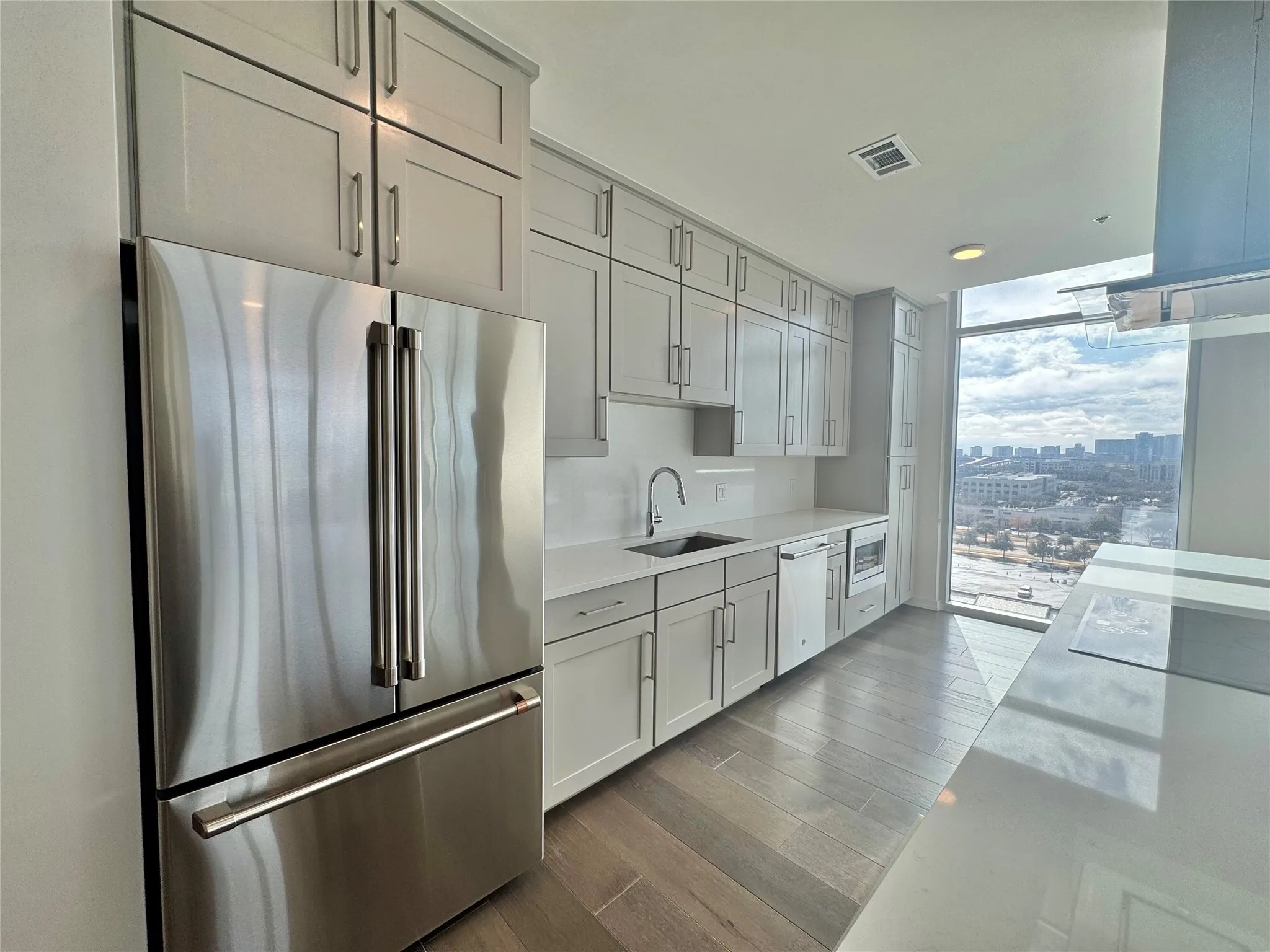 Kitchen with light hardwood / wood-style flooring, sink, a wall of windows, and appliances with stainless steel finishes