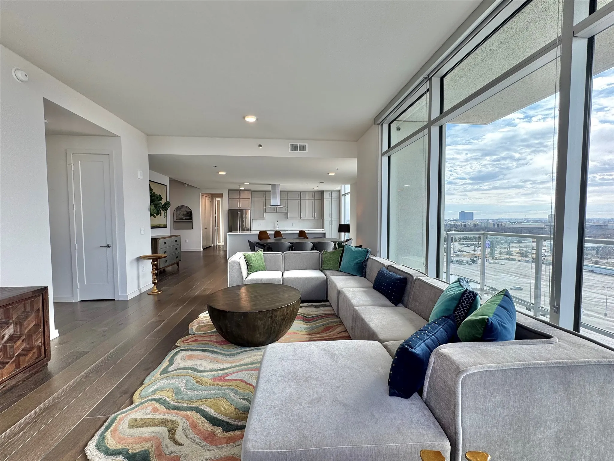 Living room featuring dark wood-type flooring and a wall of windows