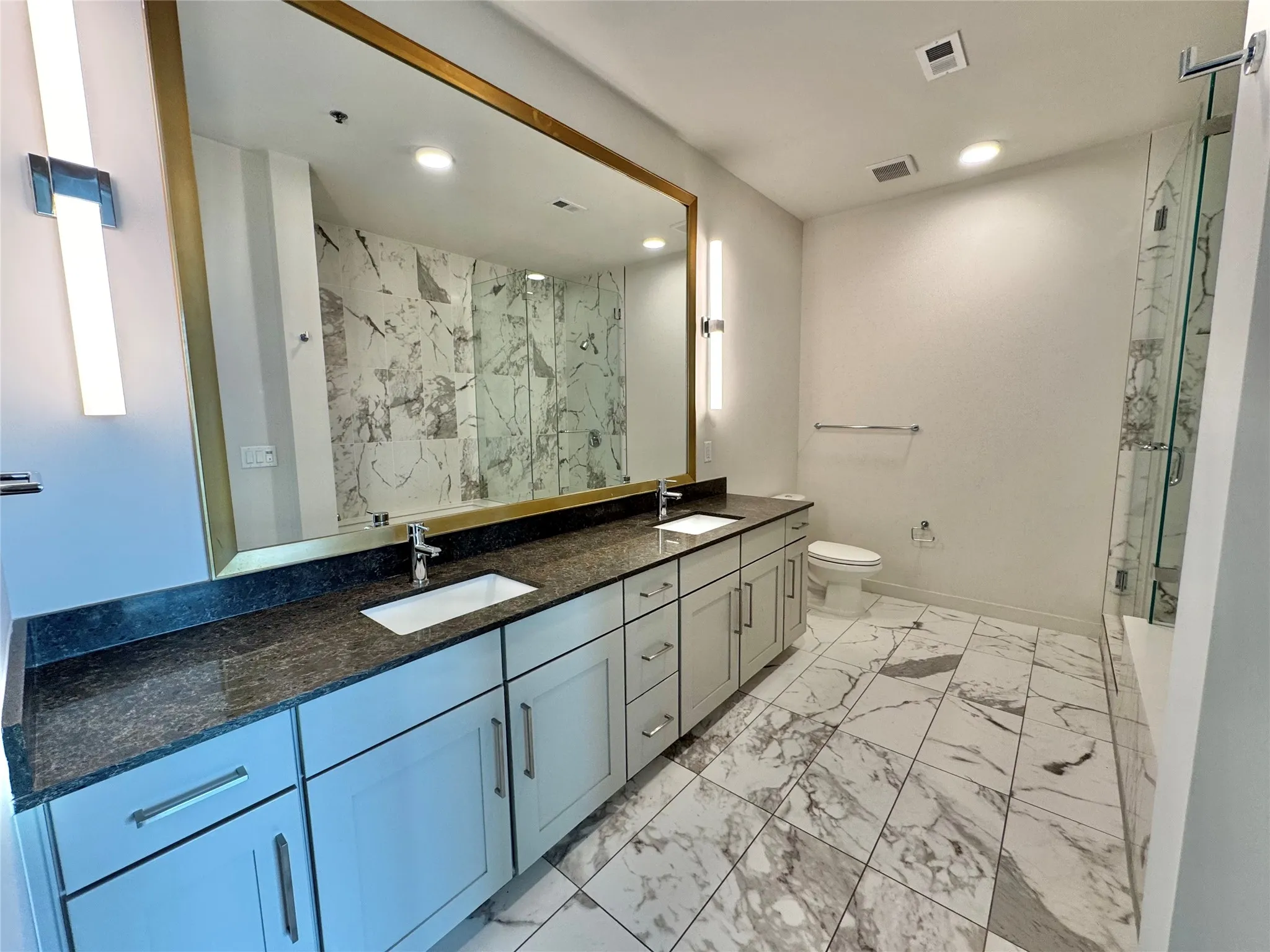 Bathroom featuring vanity, toilet, and walk in shower