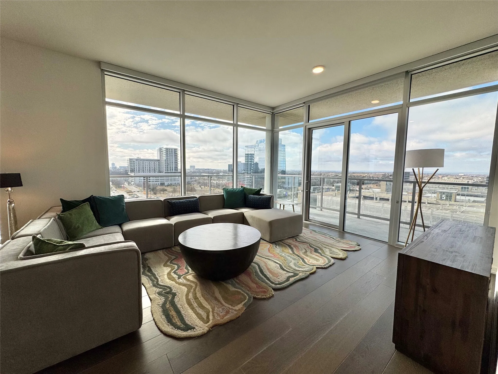 Living room featuring expansive windows, a healthy amount of sunlight, and hardwood / wood-style floors
