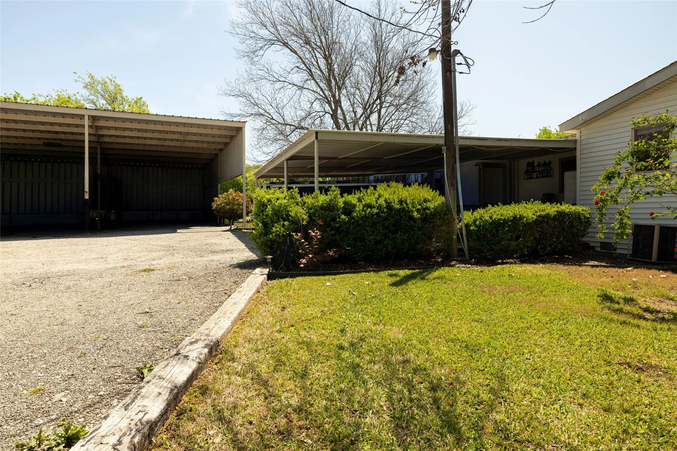 Expansive gravel parking area featuring covered RV spaces and carports.
