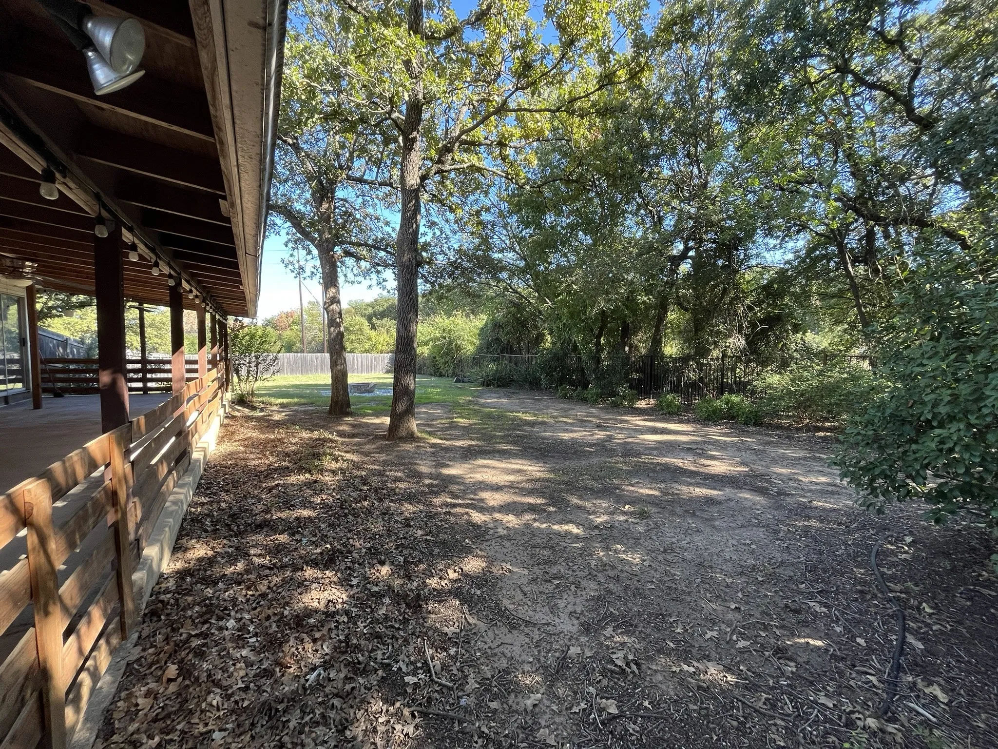 Expansive outdoor covered patio with wood slat railings, offering an extended living space