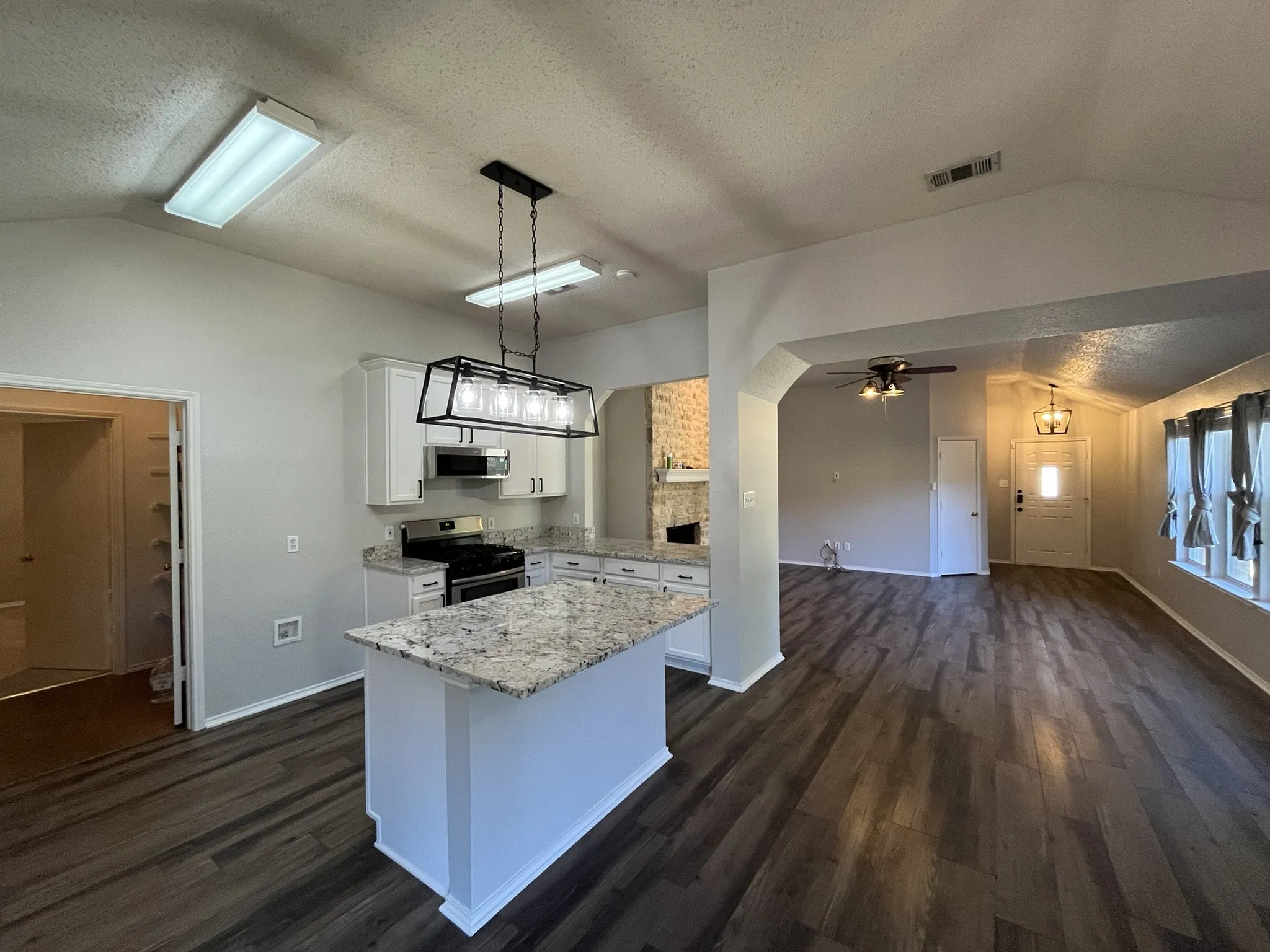 Kitchen featuring a central island, white cabinetry, and stainless steel appliances