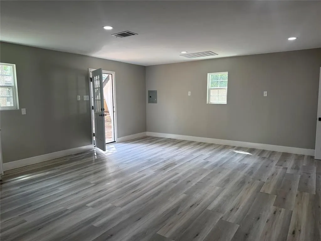 Interior space featuring wood-finish flooring, recessed lighting, and a single-pane glass entry door