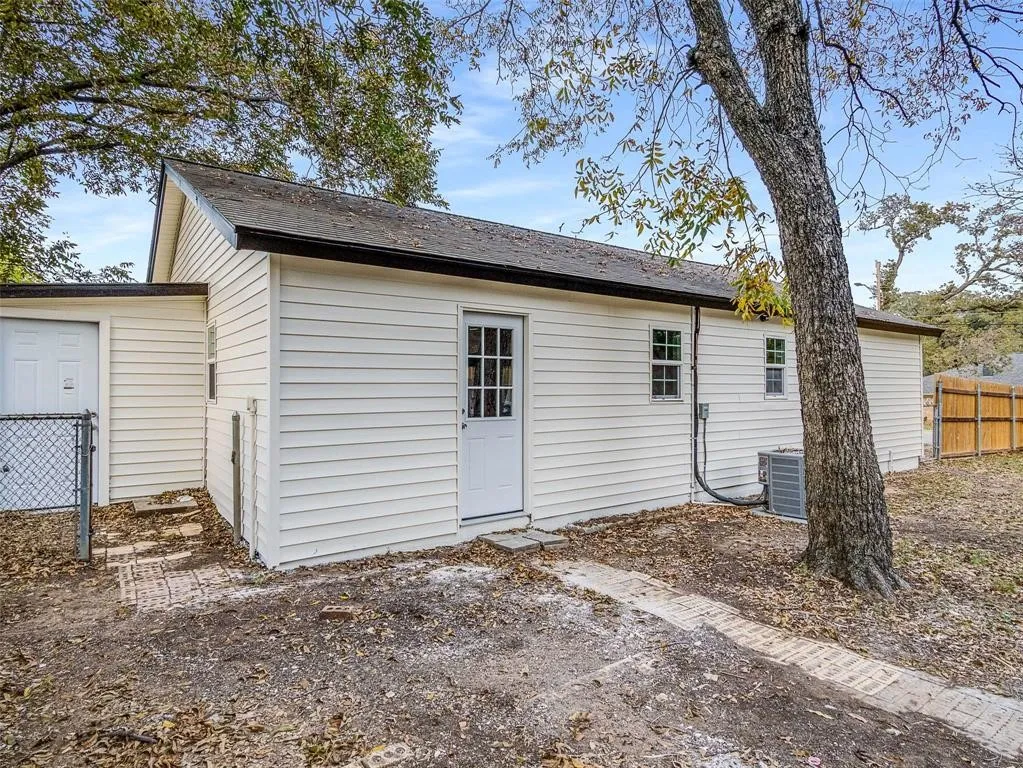 Exterior featuring light-colored horizontal siding, asphalt shingle roof, multi-pane glass entry door, and attached outdoor HVAC unit