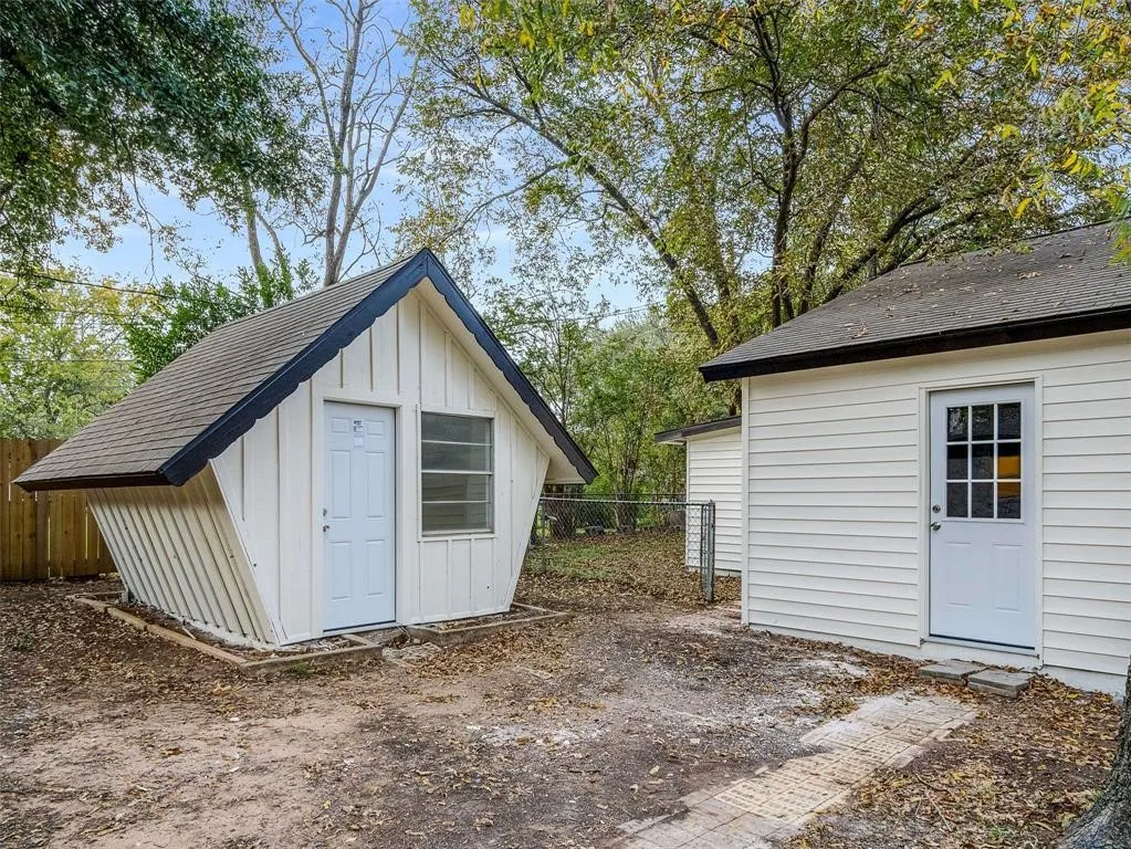 Outbuildings featuring board-and-batten and horizontal lap siding, peaked rooflines, and multi-pane glass entry doors