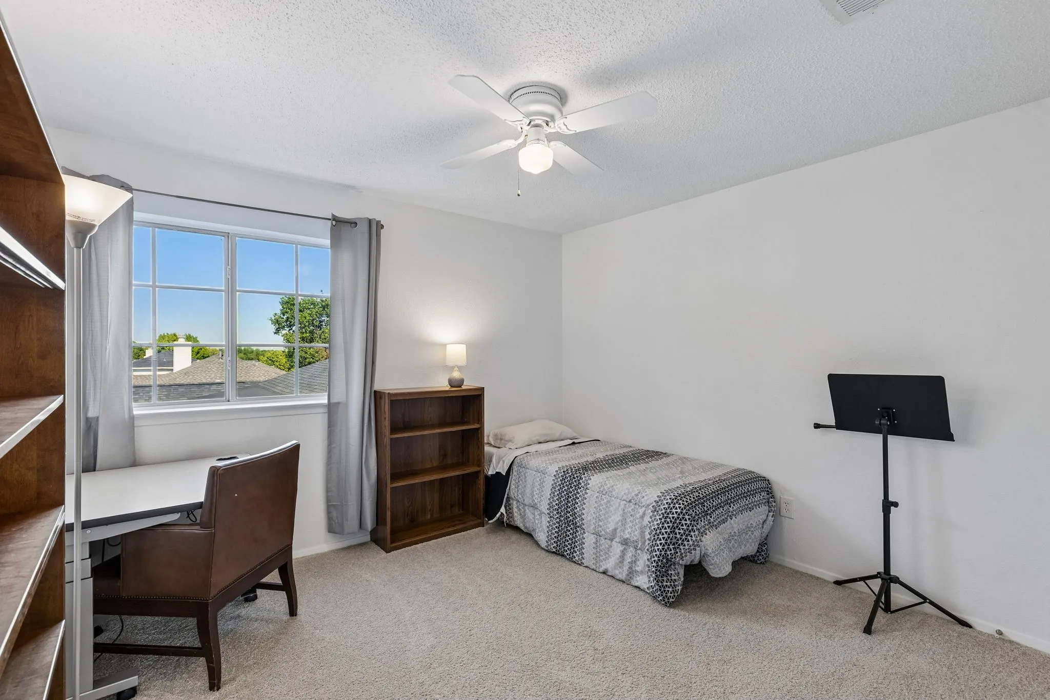 Neutral-toned carpeting, white walls, and a ceiling-mounted light fixture with a fan
