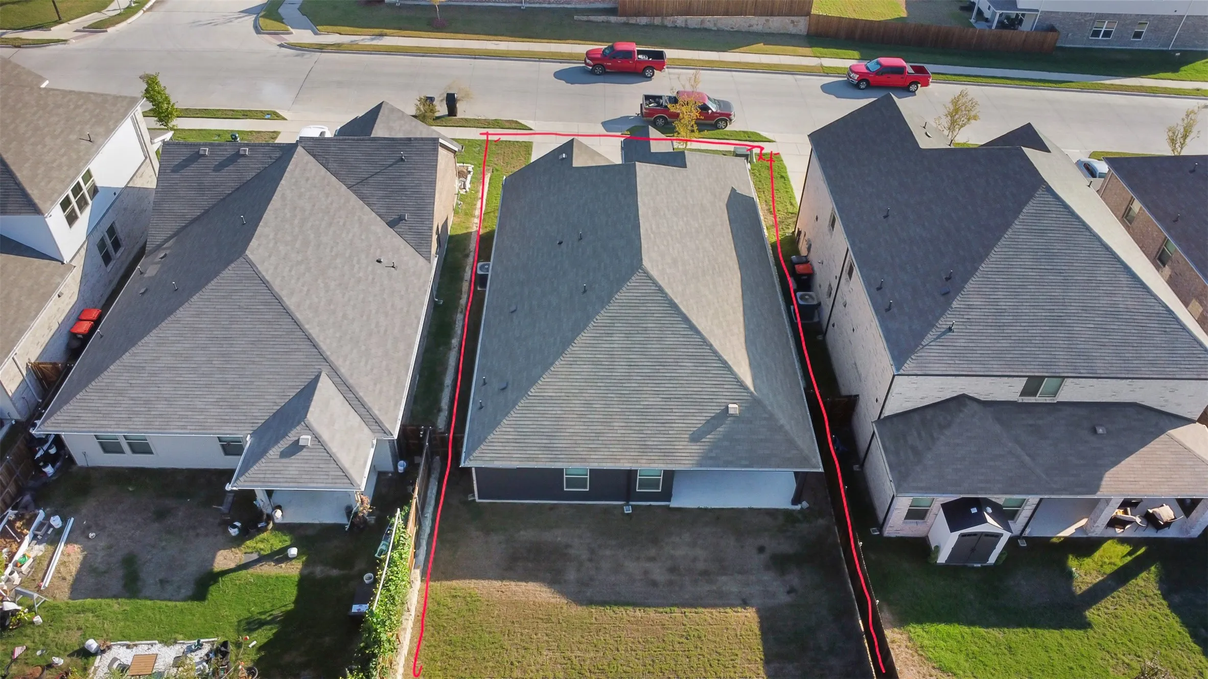 Aerial perspective of a detached residential property featuring a hipped roof, covered rear patio, and a fenced backyard