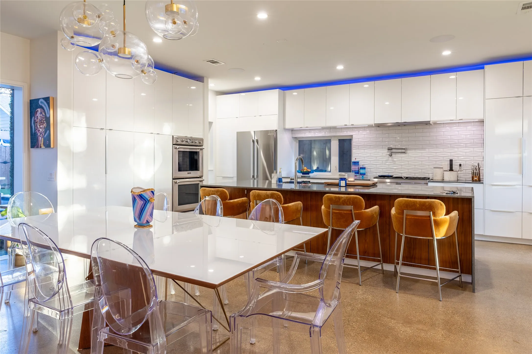 The kitchen island features a top-of-the-line stainless Thermador Professional Series gas range and double ovens.