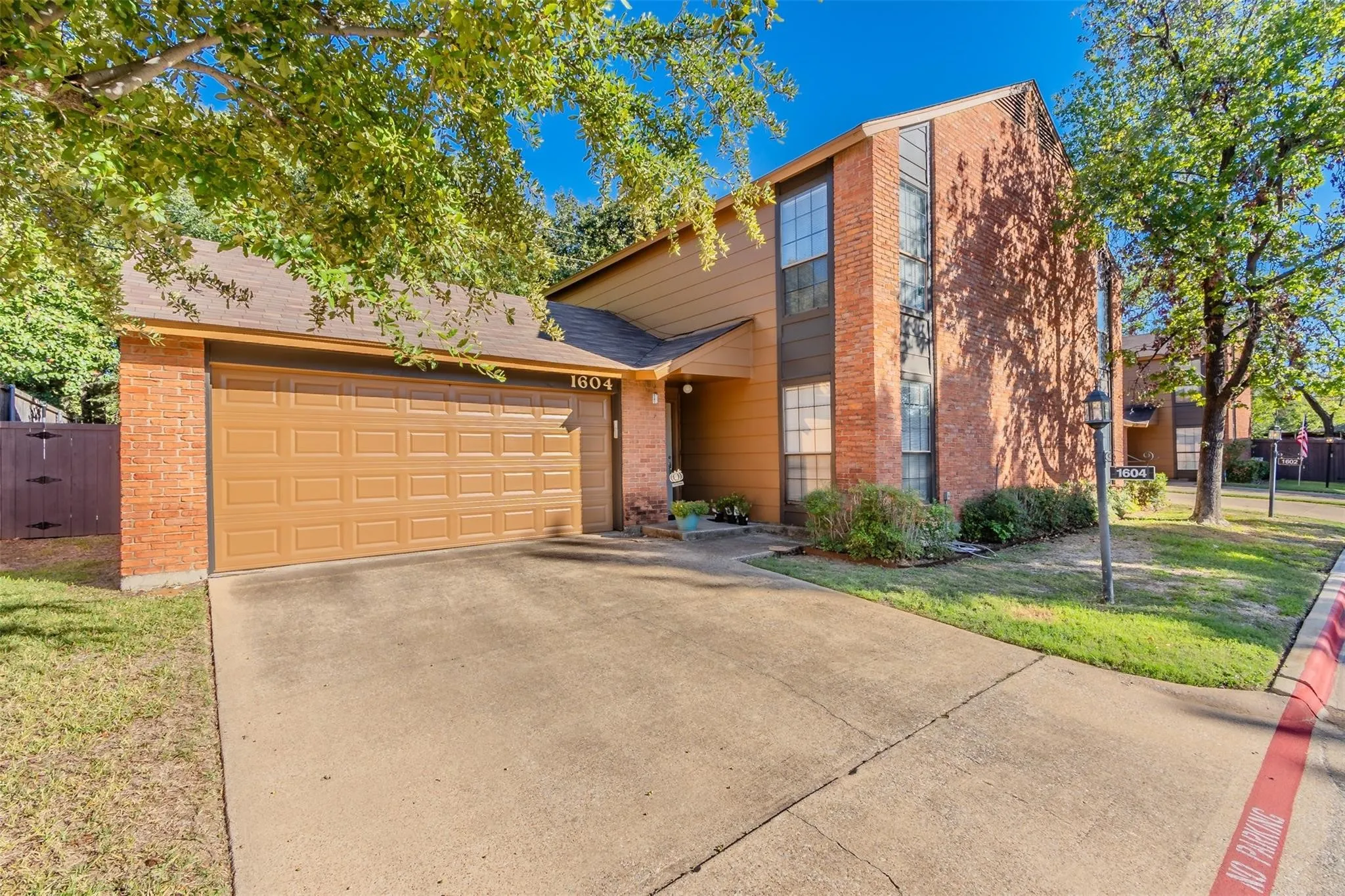 Two-story residence featuring a brick and horizontal siding exterior, a two-car garage, and an attached concrete driveway