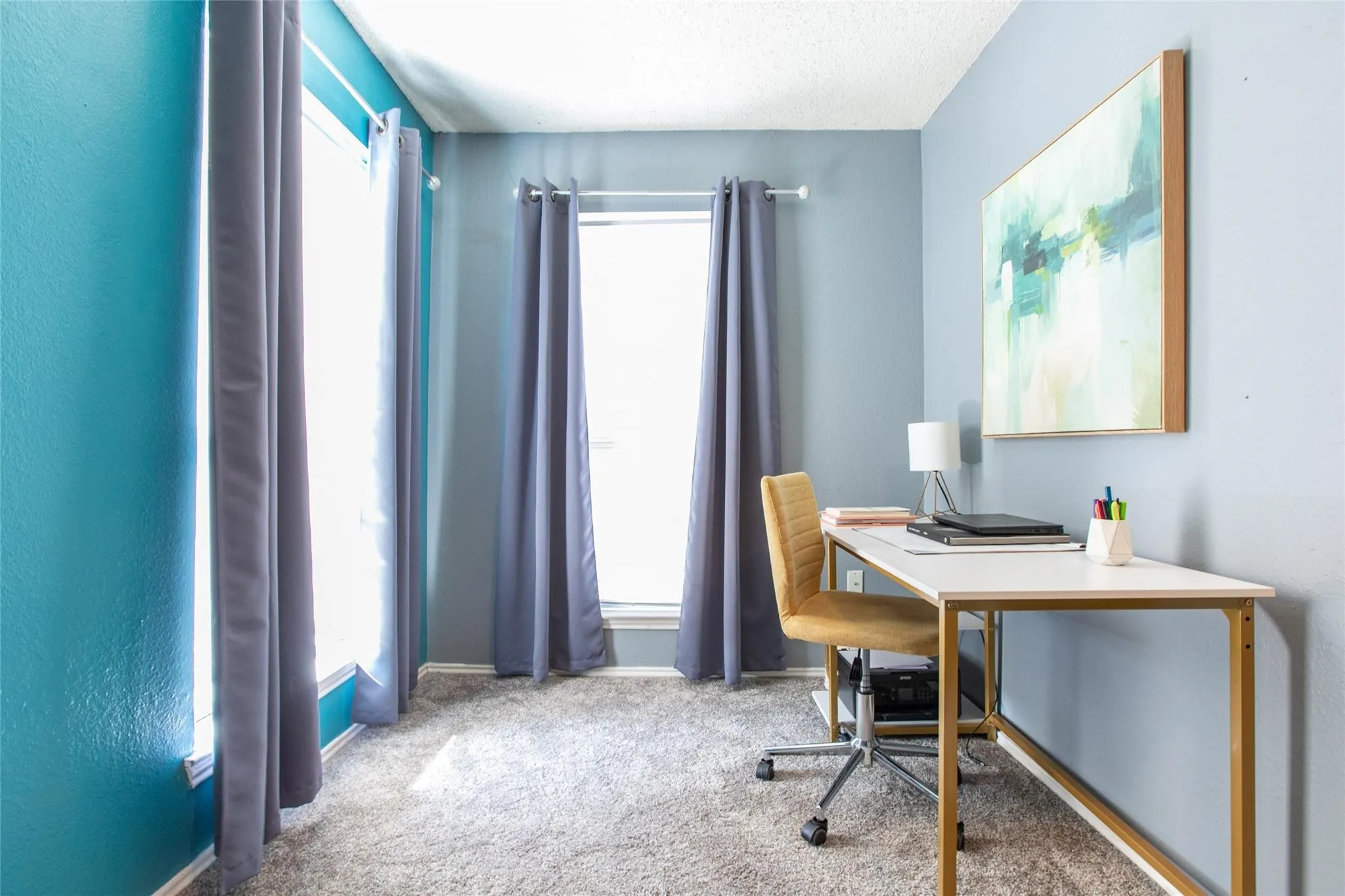 Room featuring dual-tone painted walls, neutral carpeting, and two expansive windows