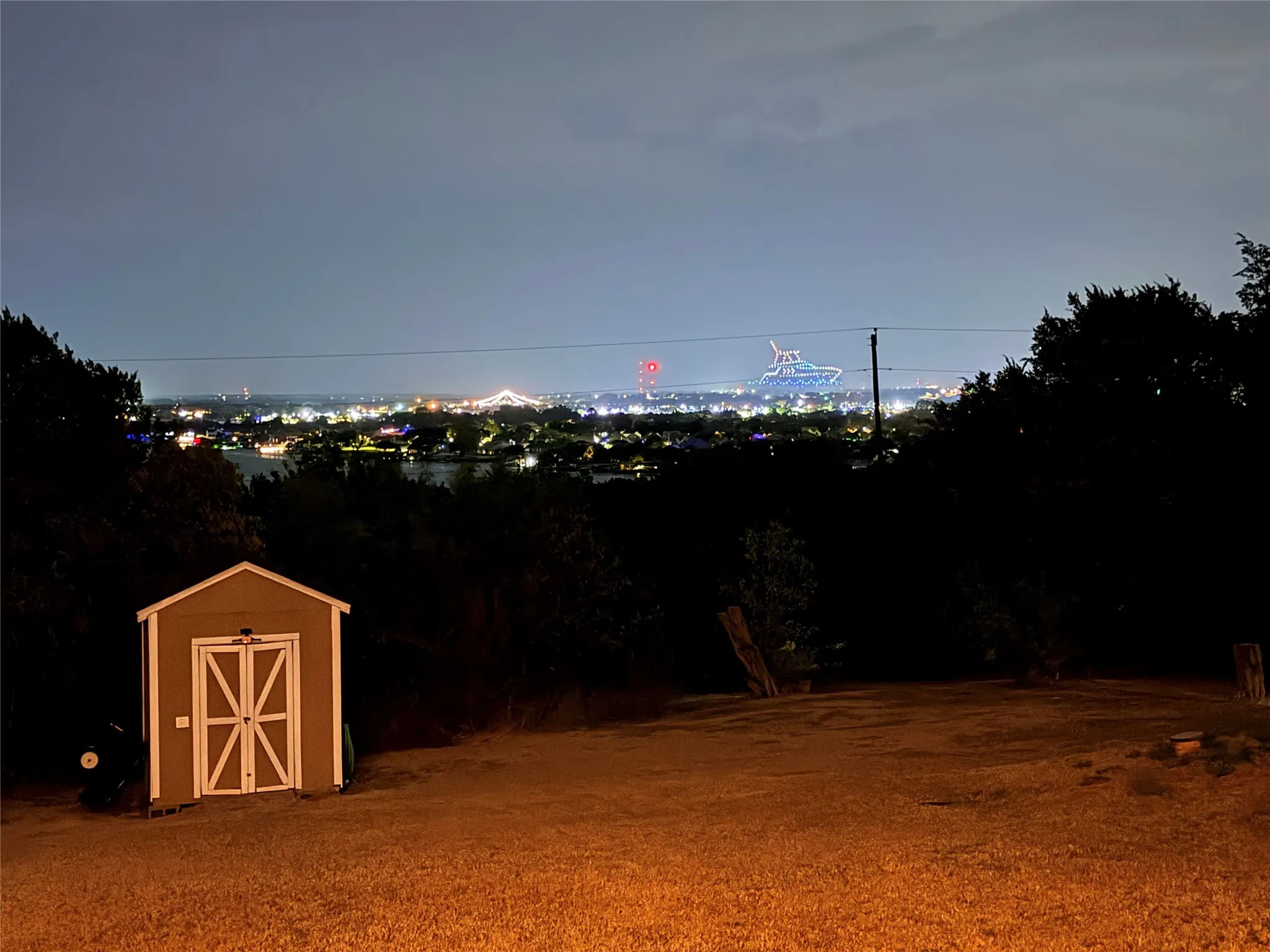 Expansive elevated lot featuring mature trees, a detached storage shed, and panoramic horizon scenery