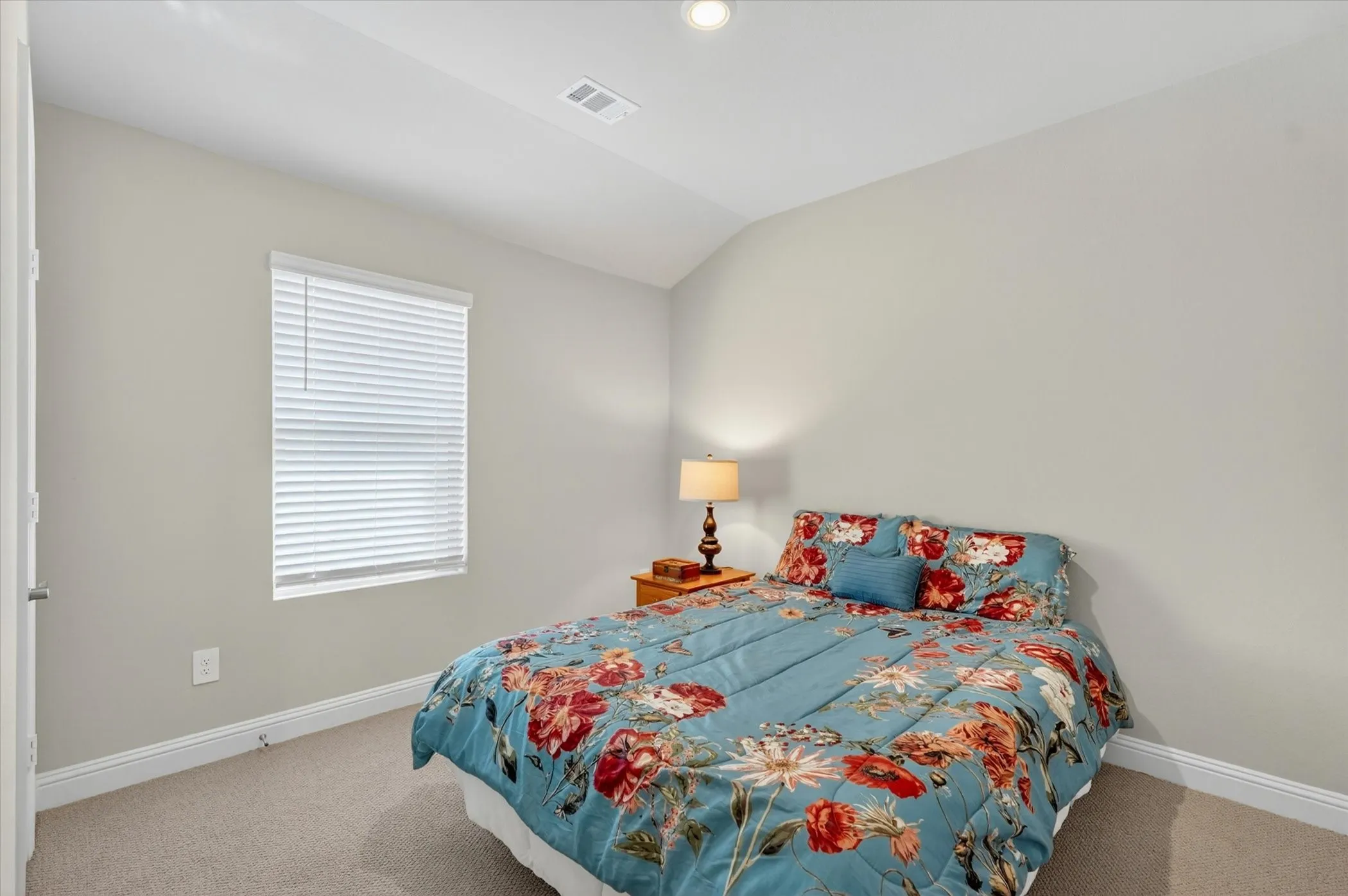 Carpeted room with light neutral walls, white trim, and a single window featuring horizontal blinds
