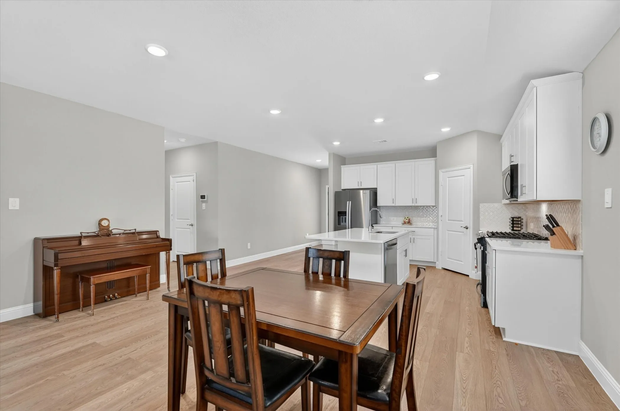 Open-concept living area featuring wood-finish flooring, recessed lighting, and light gray wall paint