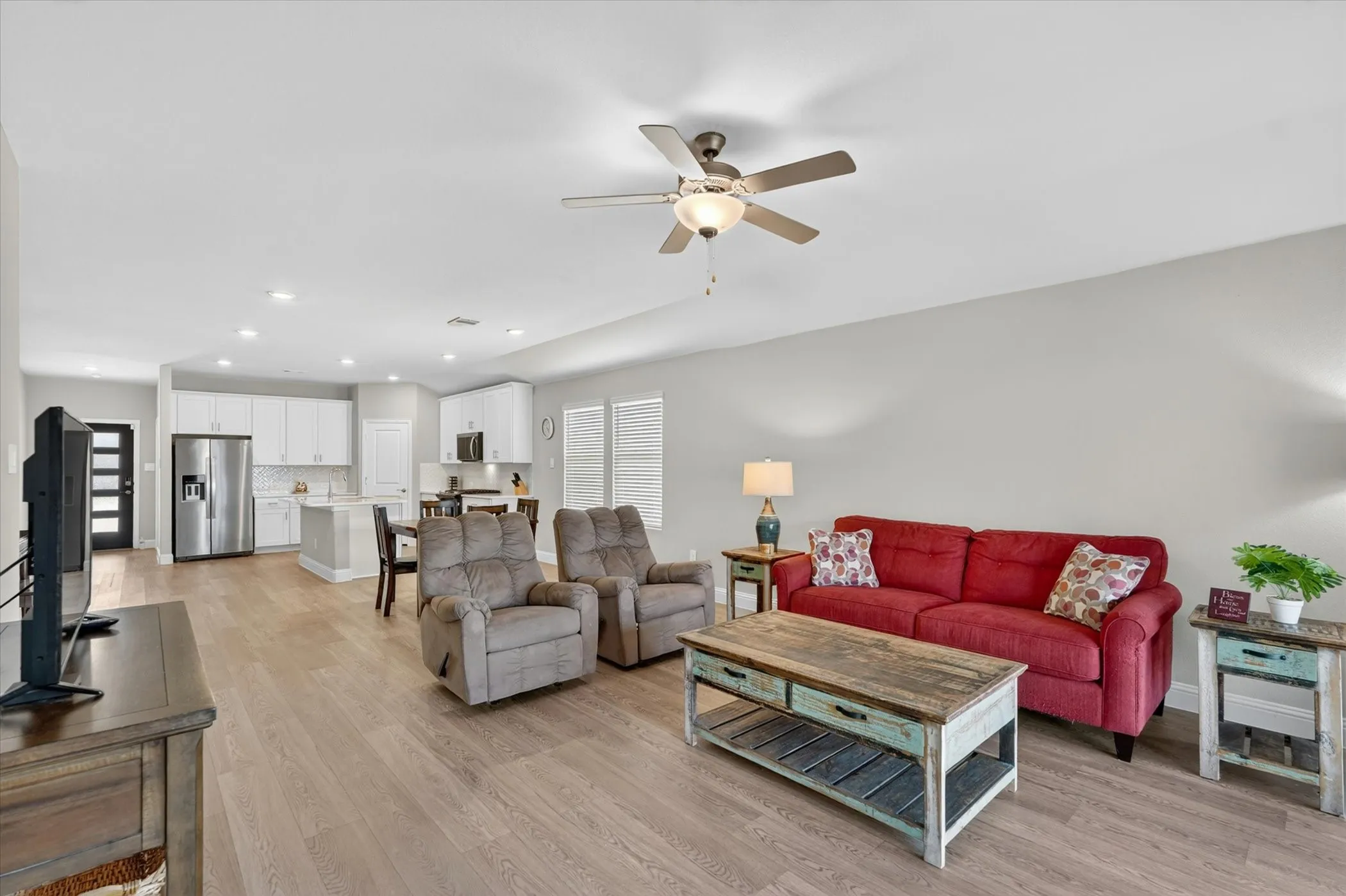Open-concept living space featuring wood-finish flooring, recessed lighting, and a ceiling fan