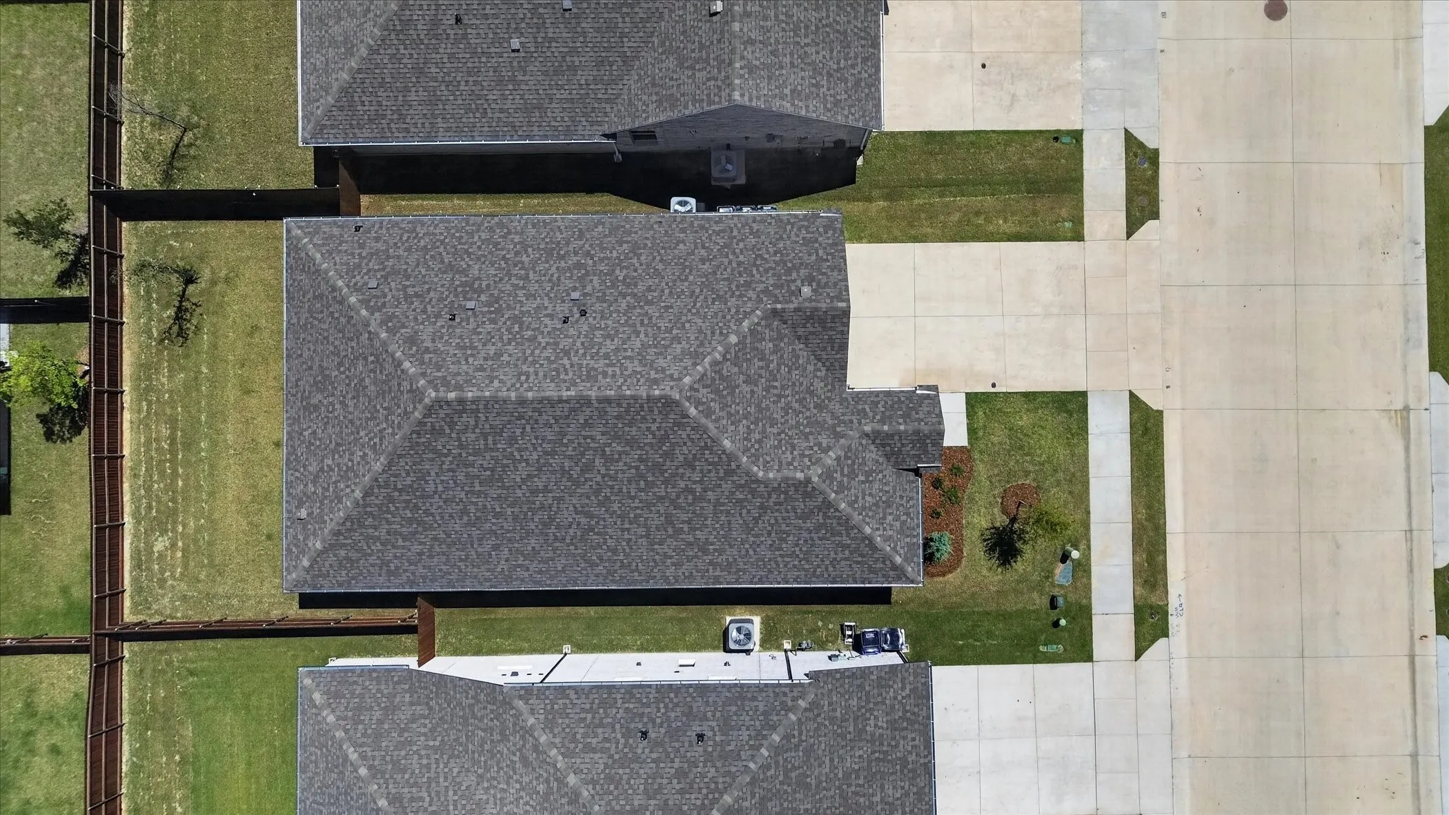Aerial view showcasing a residential property with a gray asphalt shingle roof