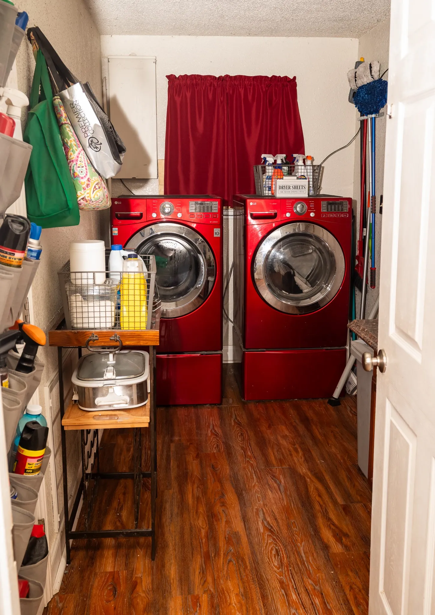 Dedicated utility space featuring wood-finish flooring and front-load laundry appliances