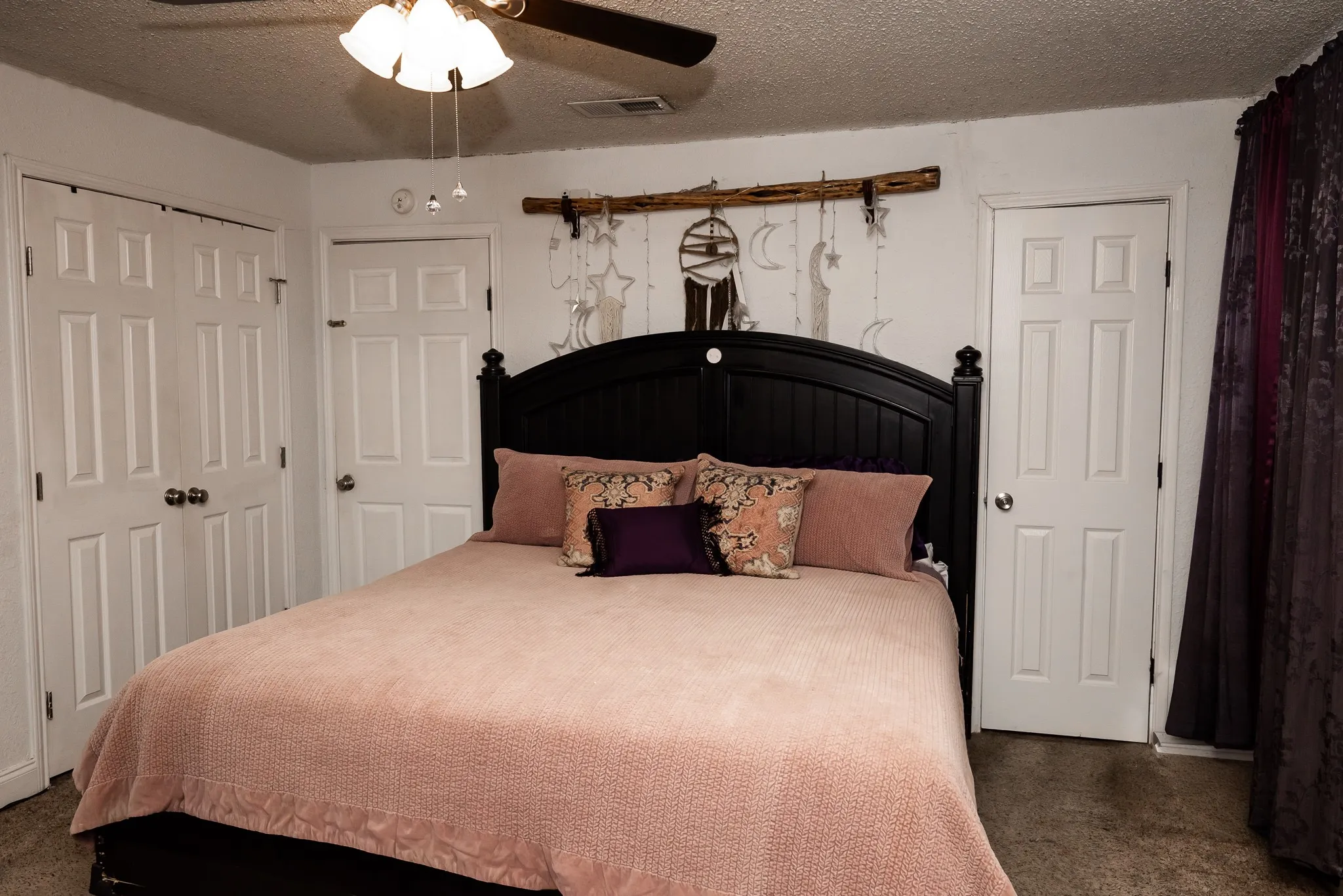 Bedroom featuring a ceiling-mounted fan with integrated light fixture, dual-door closet, and single-panel interior doors