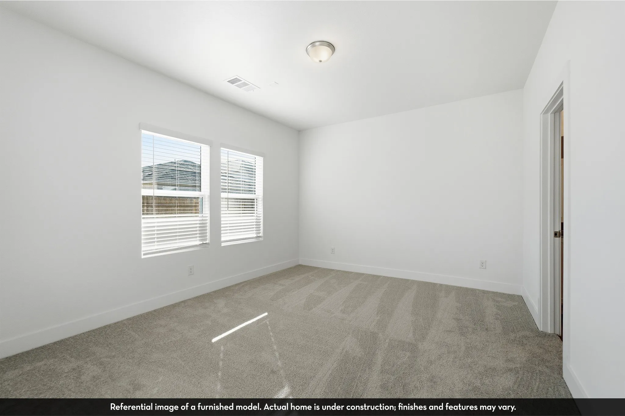 Neutral-toned wall-to-wall carpeting, dual windows with horizontal blinds, and a flush-mount overhead light fixture