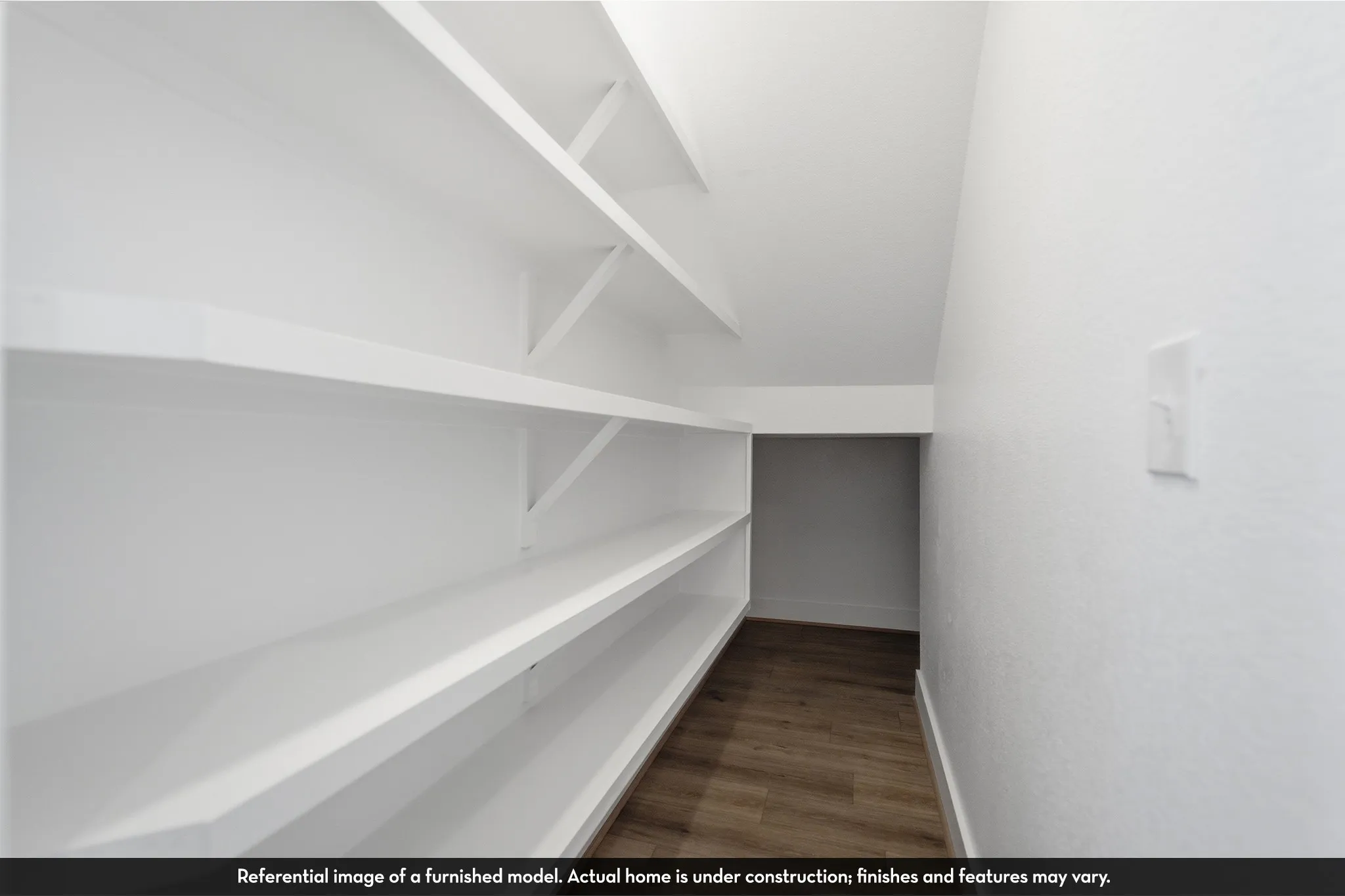 Storage area featuring white built-in shelving and wood-finish flooring