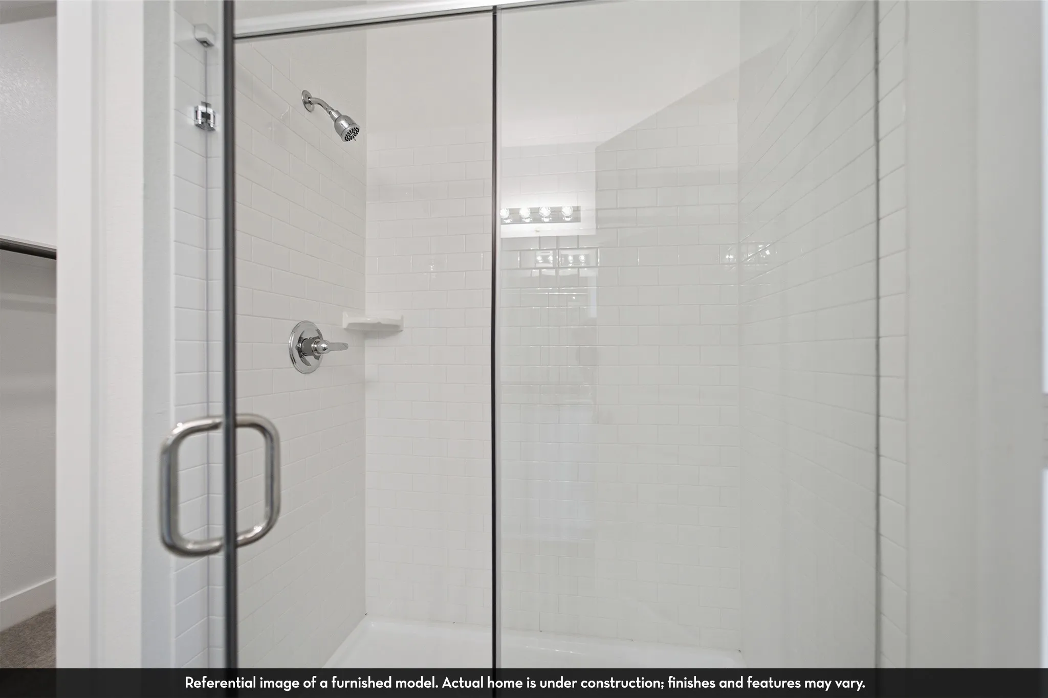 Walk-in shower featuring subway tile surround, frameless glass enclosure, built-in soap niche, and chrome hardware