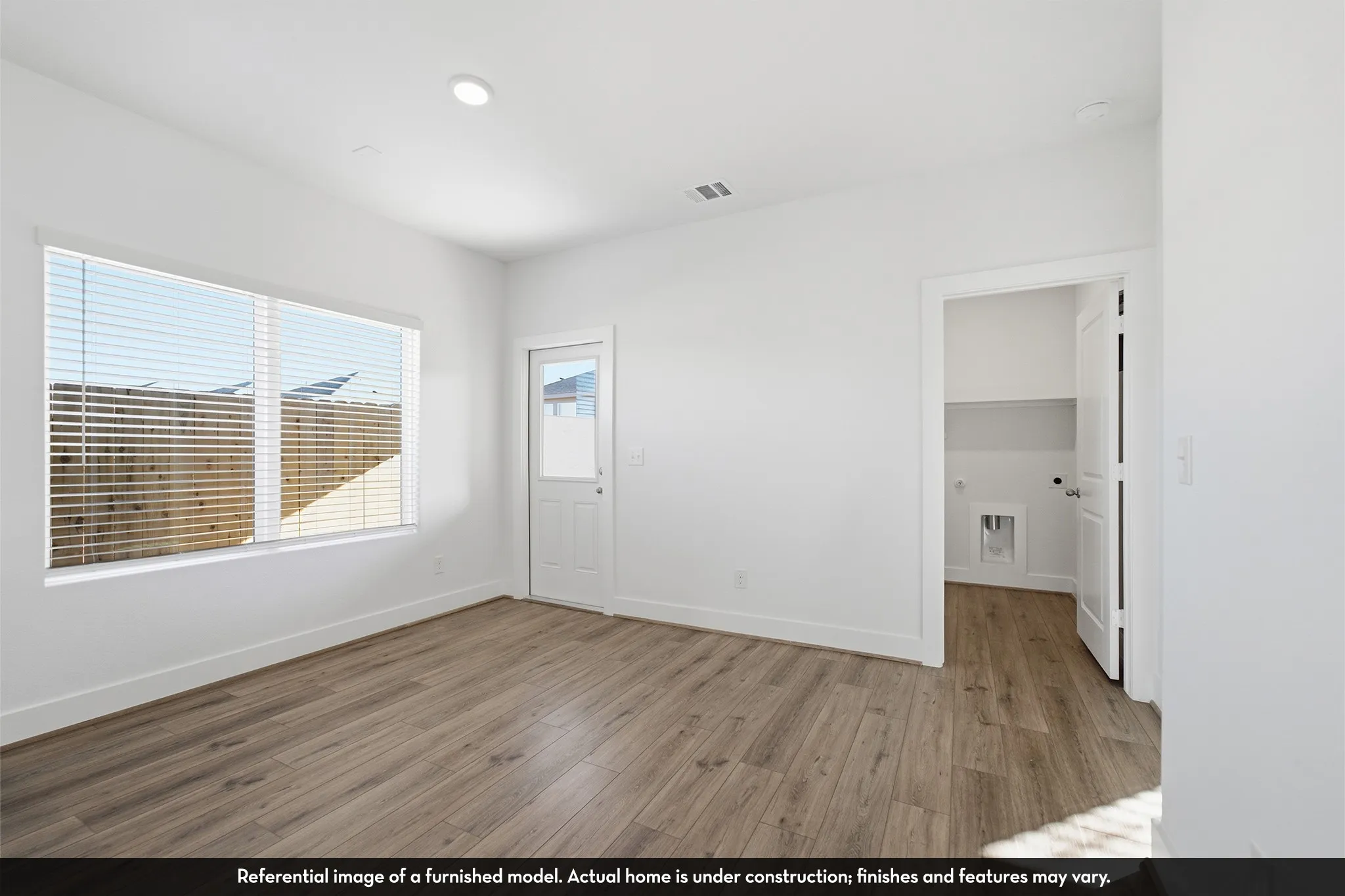 Kitchen featuring white shaker-style cabinetry, neutral solid-surface countertops, white subway tile backsplash, recessed ceiling lighting, and wood-finish flooring