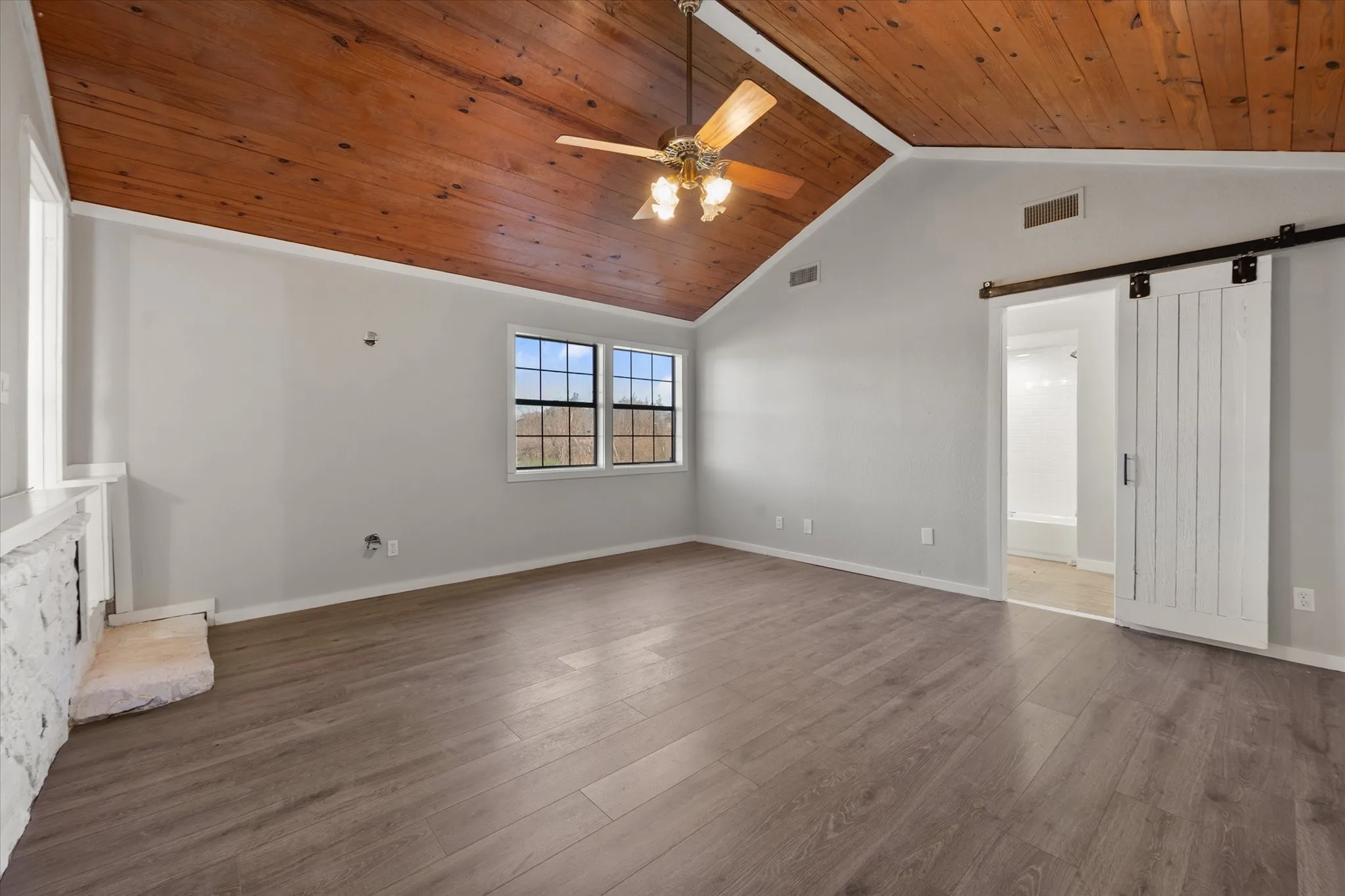 Vaulted wood-paneled ceiling with ceiling fan