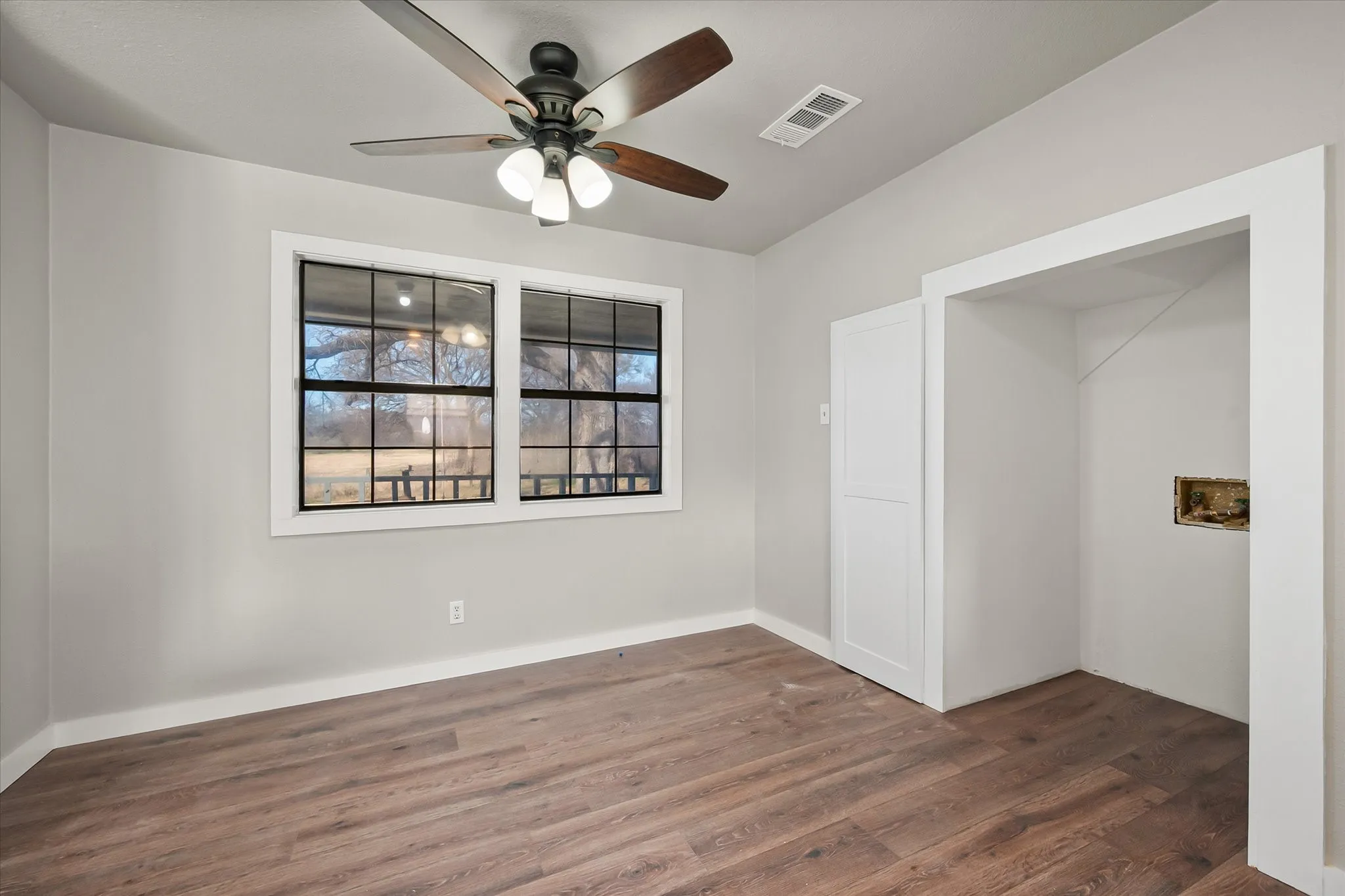 Wood-finish flooring, white trim, and light gray walls