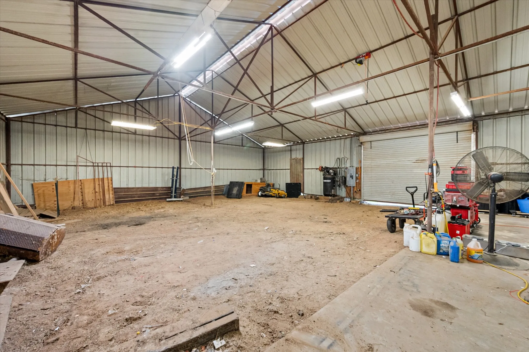 Expansive indoor structure featuring a metal frame, corrugated metal walls, and a large roll-up door