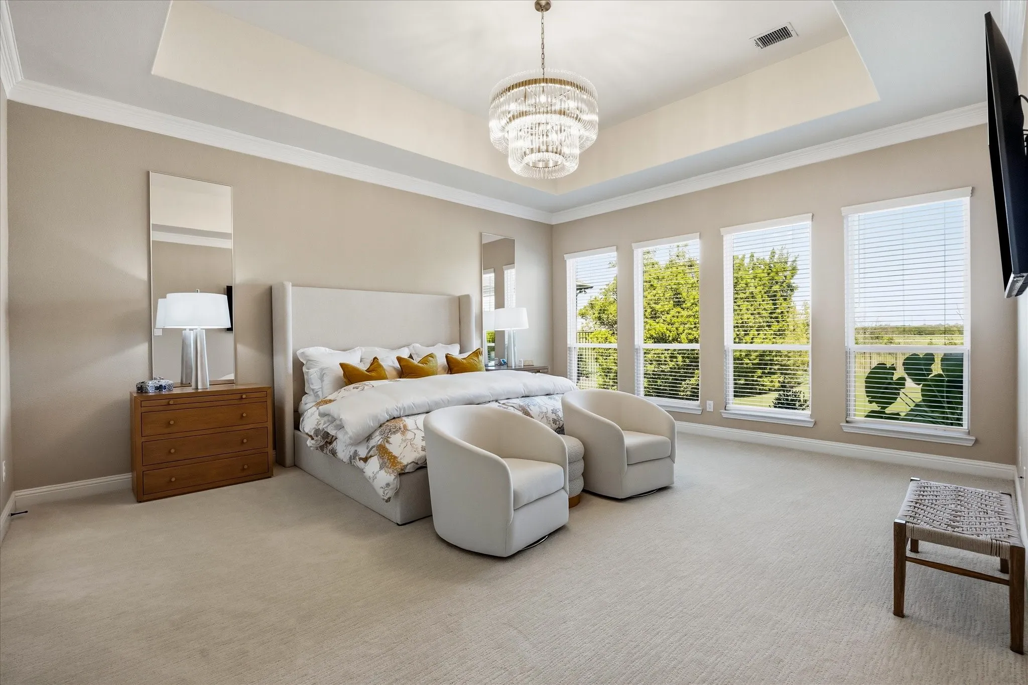 Expansive primary suite overlooking the serene pool and greenspace.
