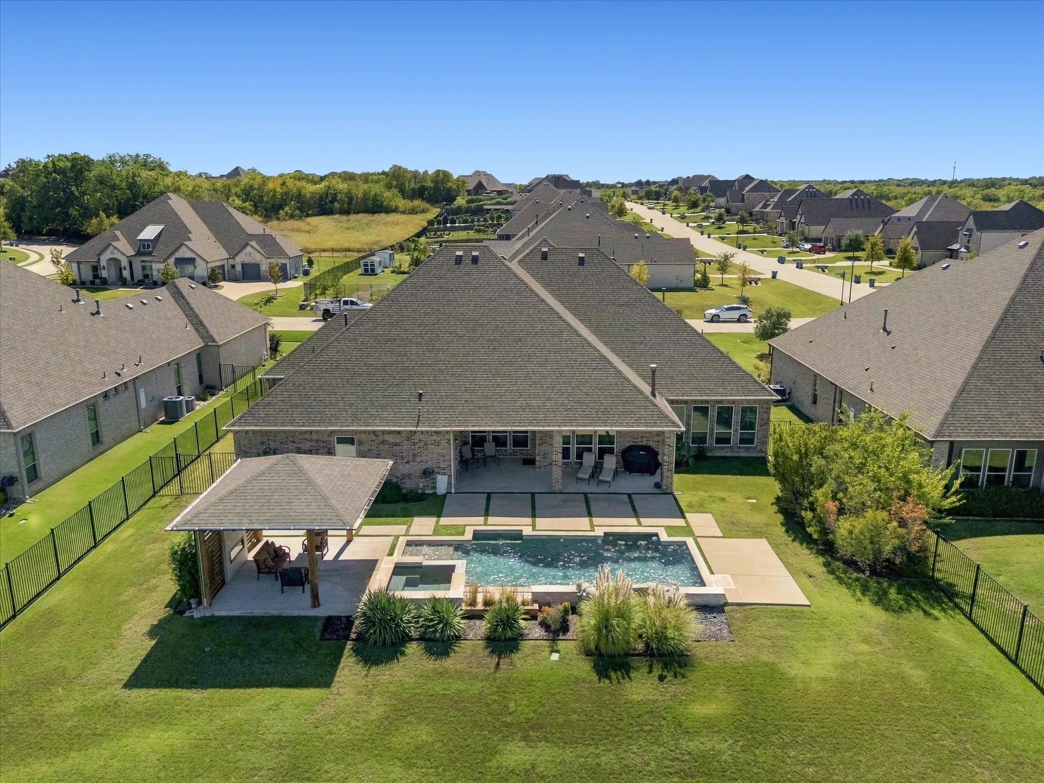Expansive backyard featuring a swimming pool, integrated spa, and an covered patio