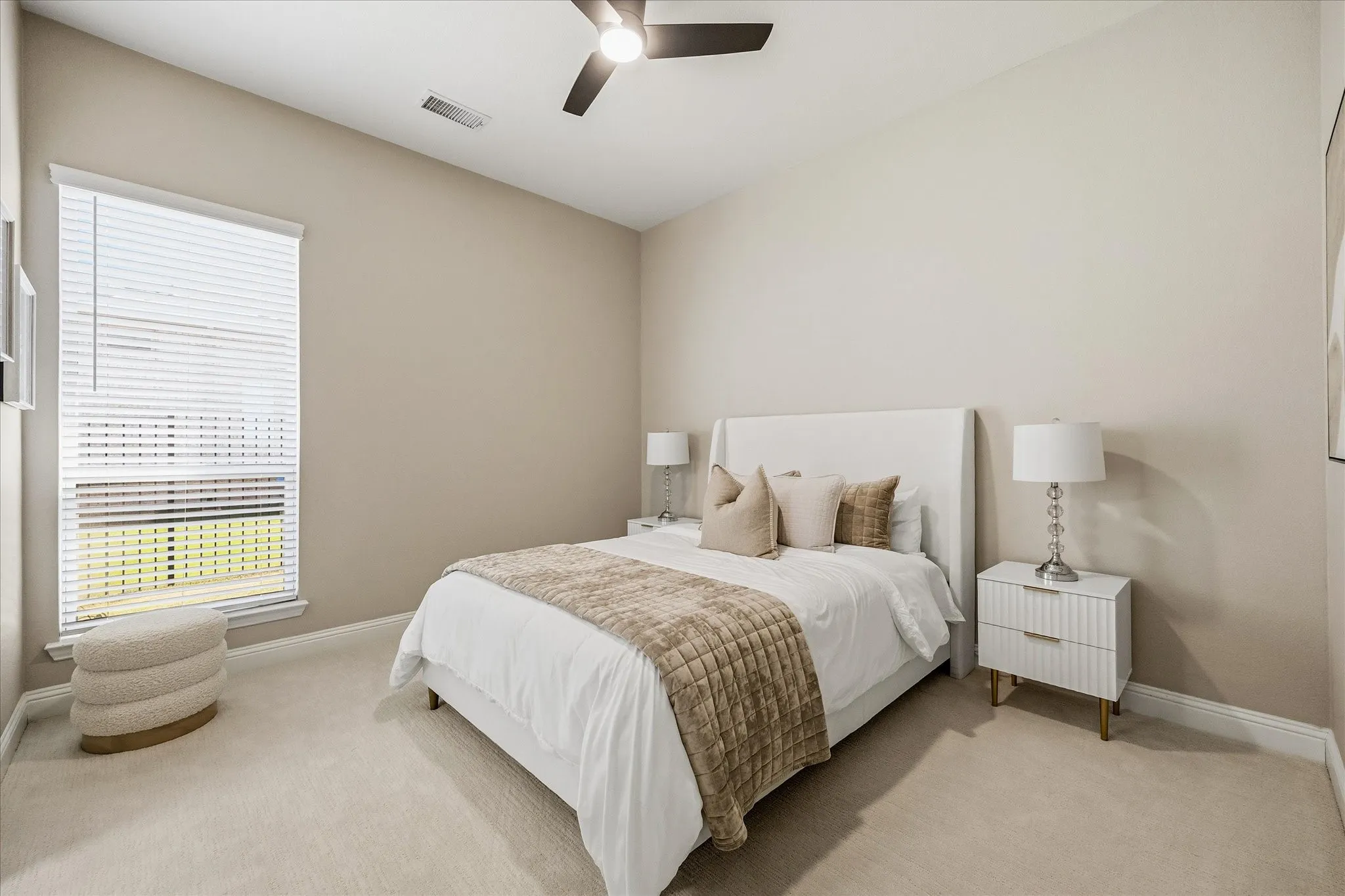 Carpeted flooring, vaulted ceiling, single window with blinds, and a ceiling fan with light fixture