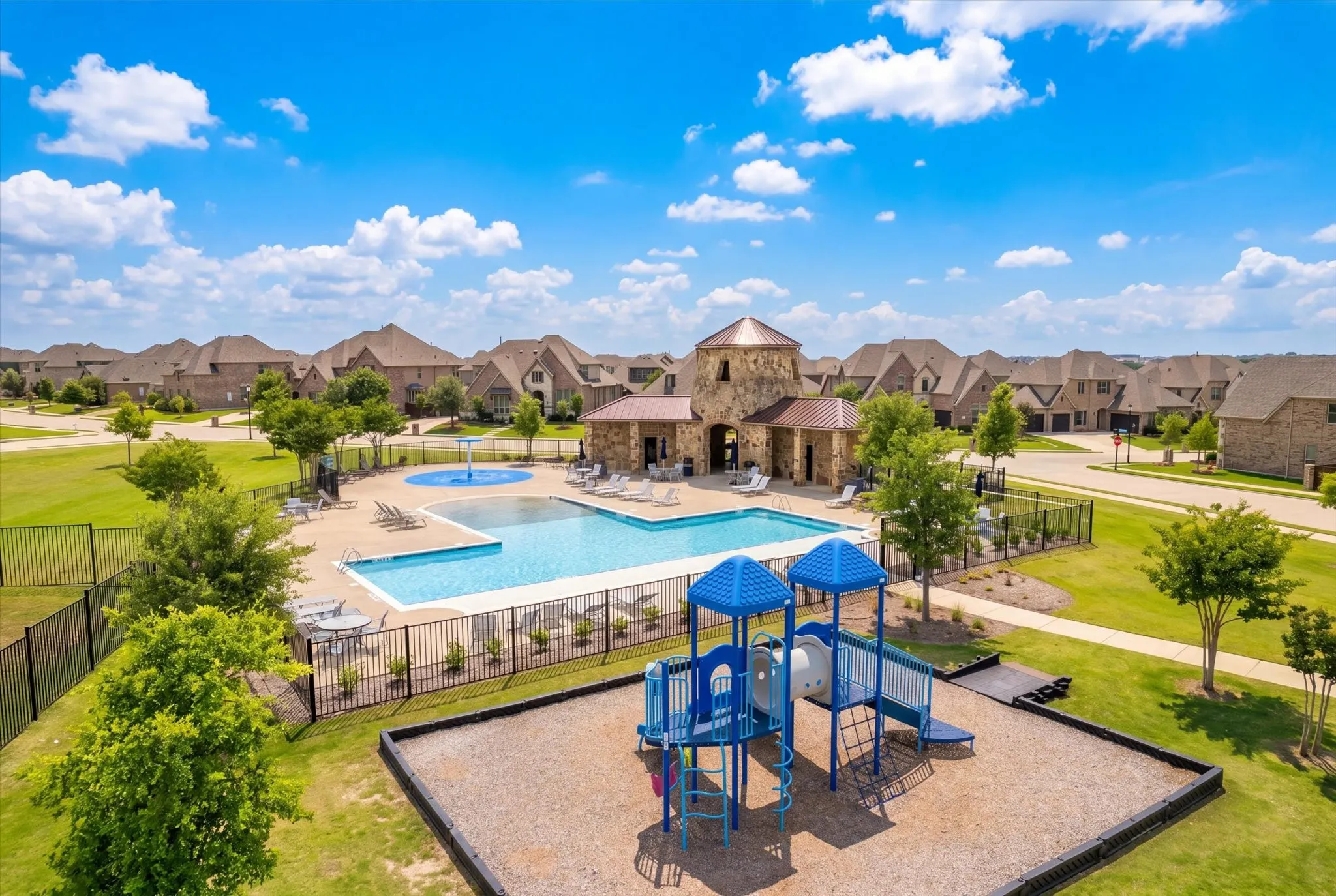 Community amenities featuring a swimming pool, splash pad, stone-accented pavilion, and a playground