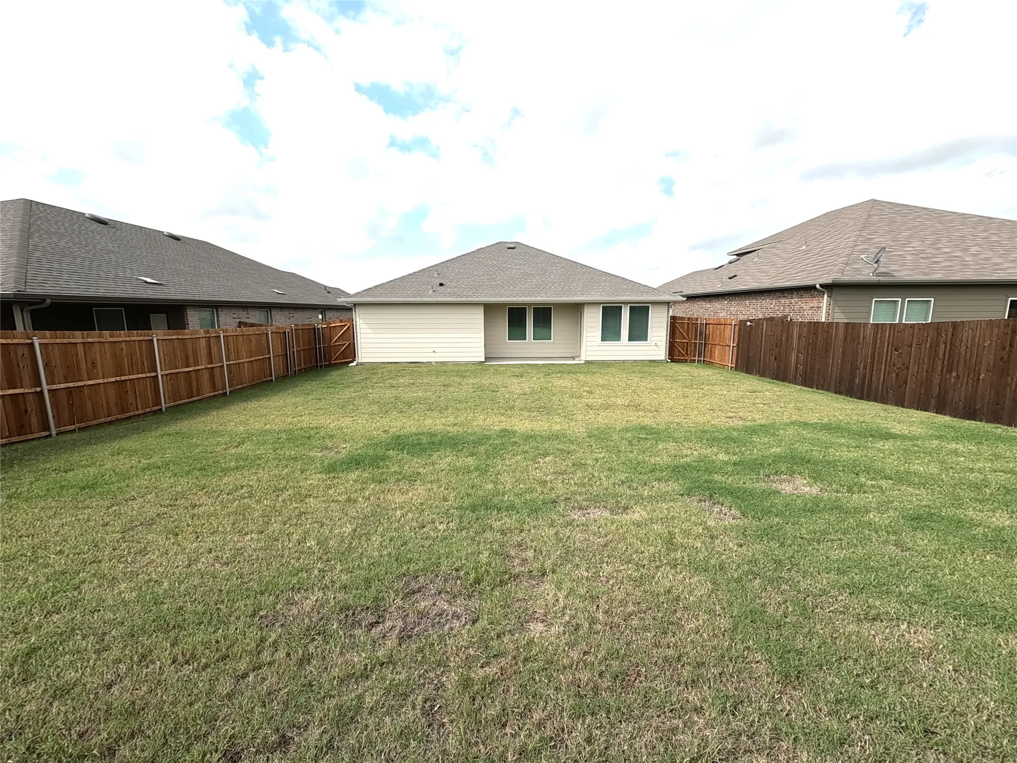 Backyard featuring a grass lawn, horizontal wood privacy fencing, and neutral-toned siding
