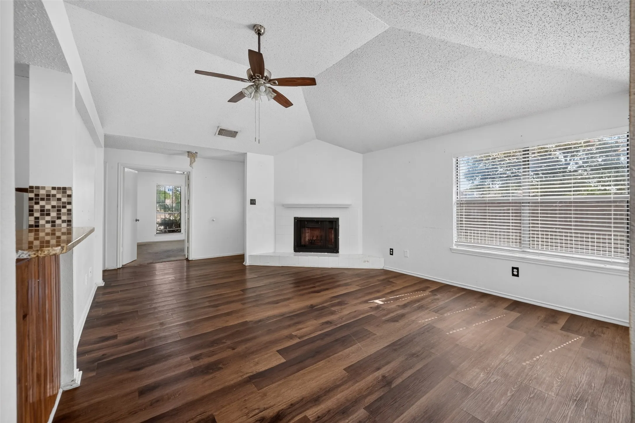 Wood-finish flooring, vaulted ceiling, and a ceiling fan