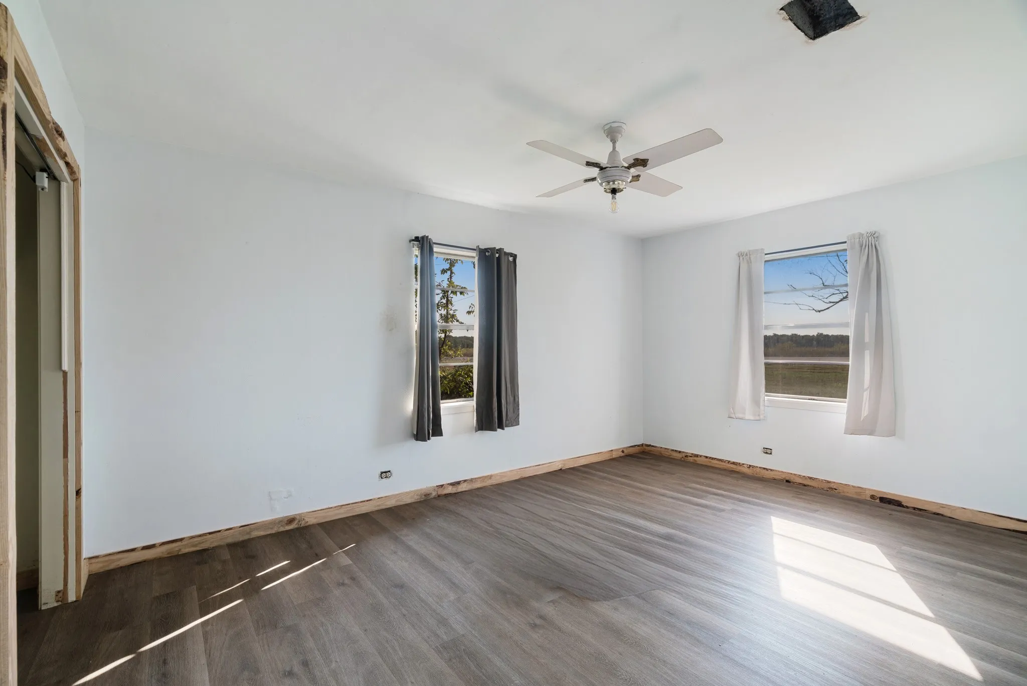 Unfurnished bedroom with wood finished floors, a ceiling fan, and a closet