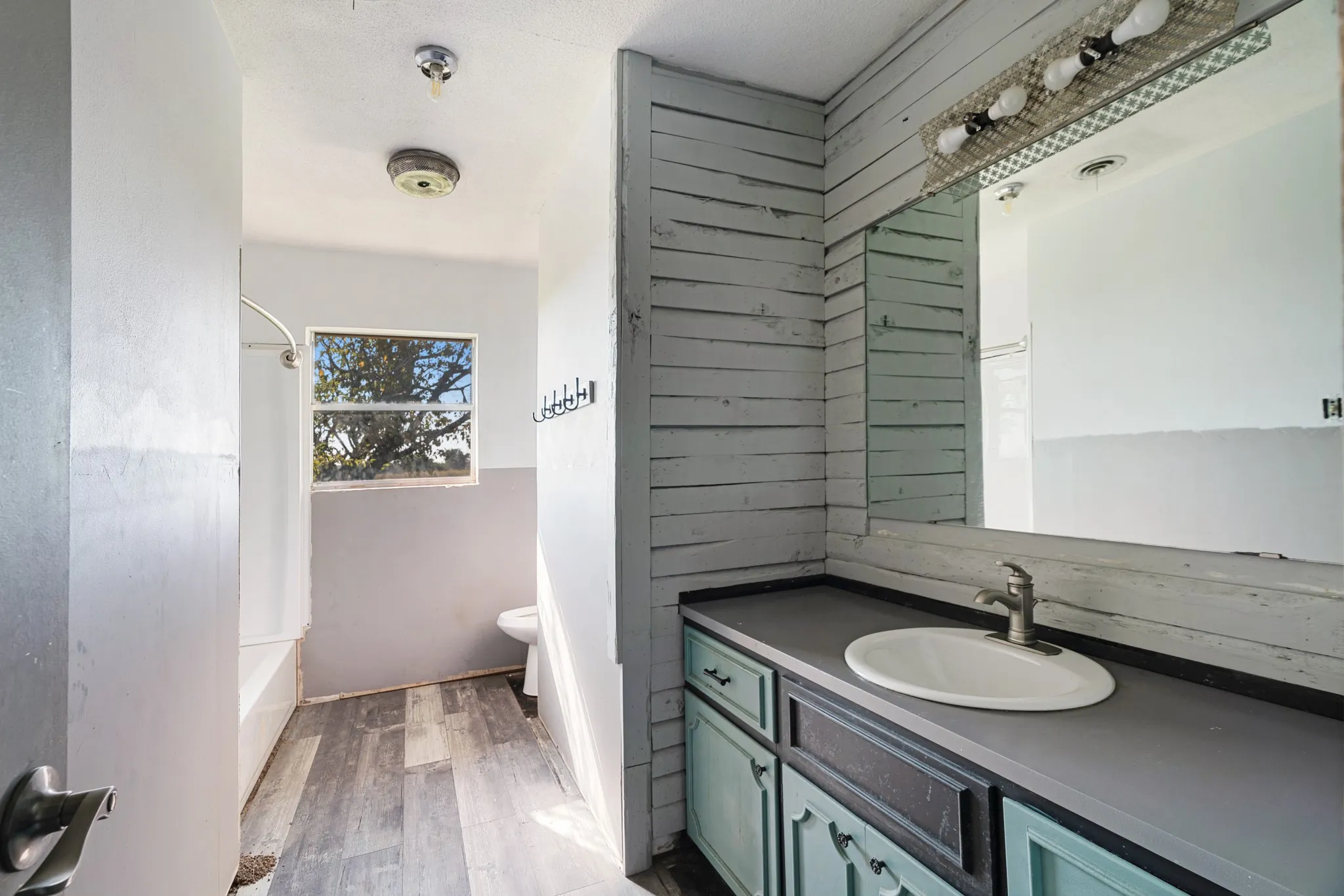 Bathroom featuring vanity, dark wood-style floors, and shower / washtub combination