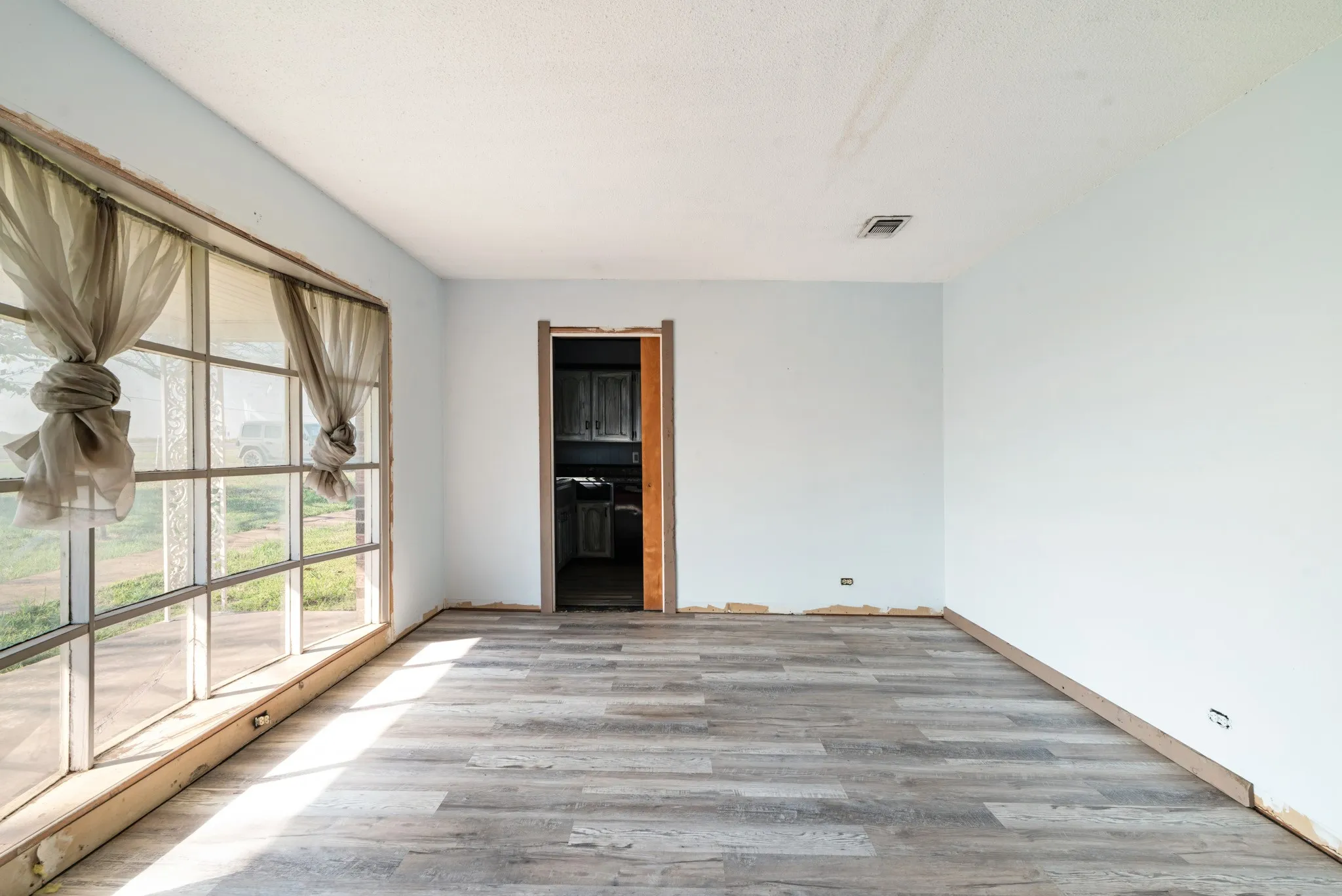 Unfurnished room with wood finished floors and a textured ceiling