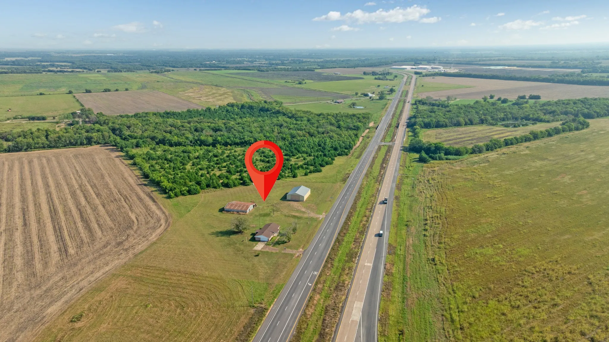Aerial view of property and surrounding area featuring farmland and rural landscape