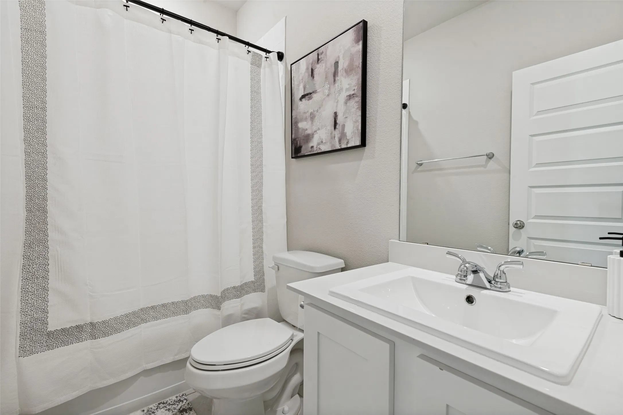 Bathroom featuring a white vanity with an integrated sink, polished chrome faucet, full-width mirror, and four-panel interior door