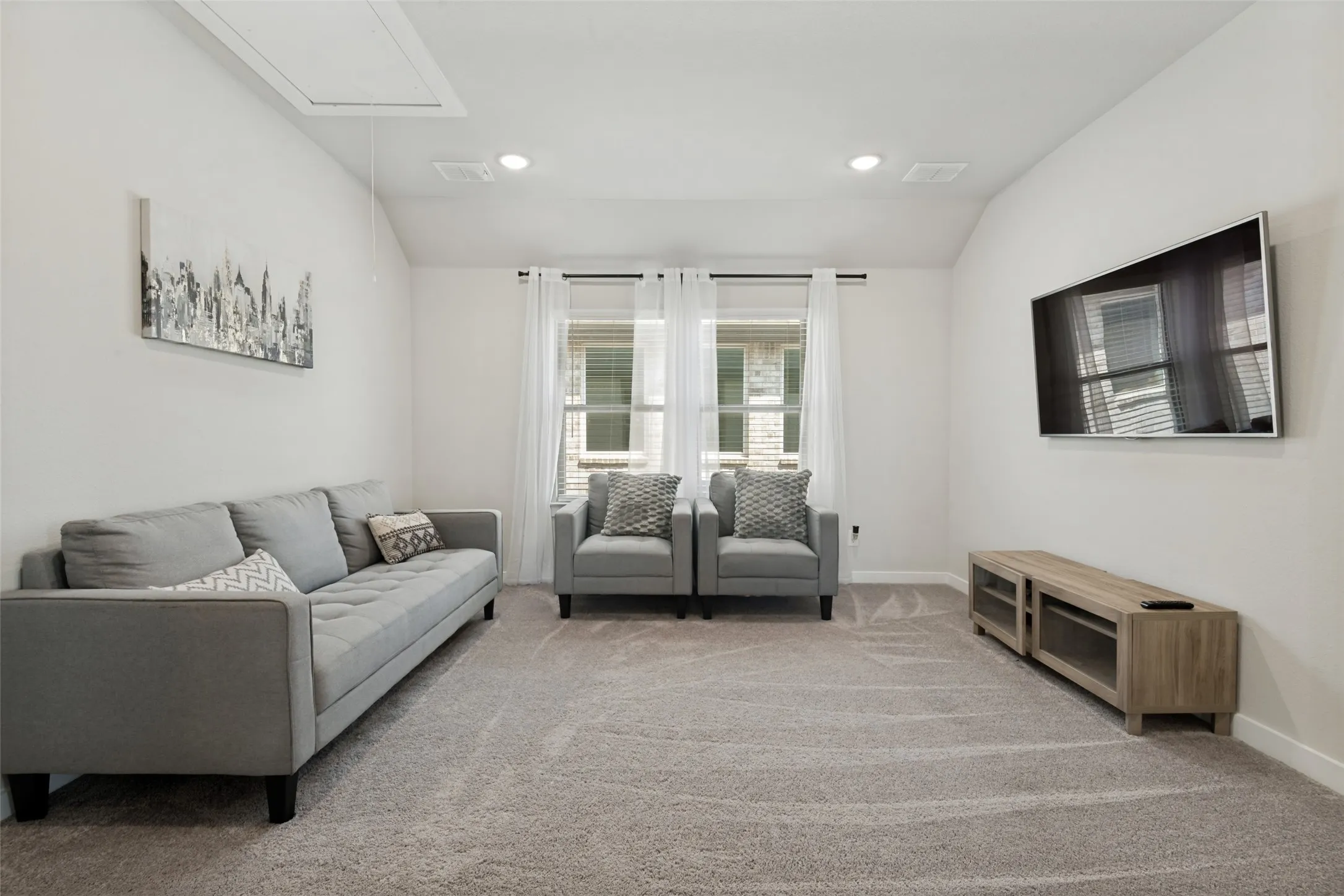 Neutral-toned interior featuring a vaulted ceiling, recessed lighting, and wall-to-wall carpeting
