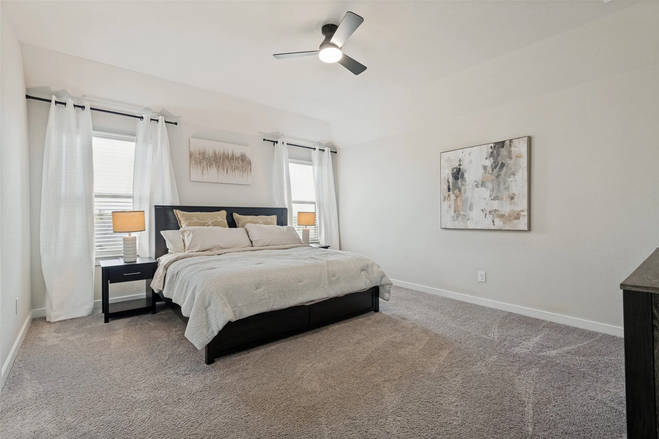 Vaulted ceilings, neutral carpeting, dual windows, and an integrated ceiling fan with light fixture